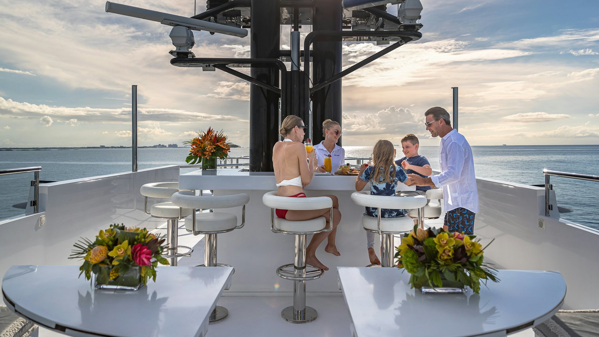 a group of people sitting at a table outside aboard HIGHLANDER Yacht for Charter