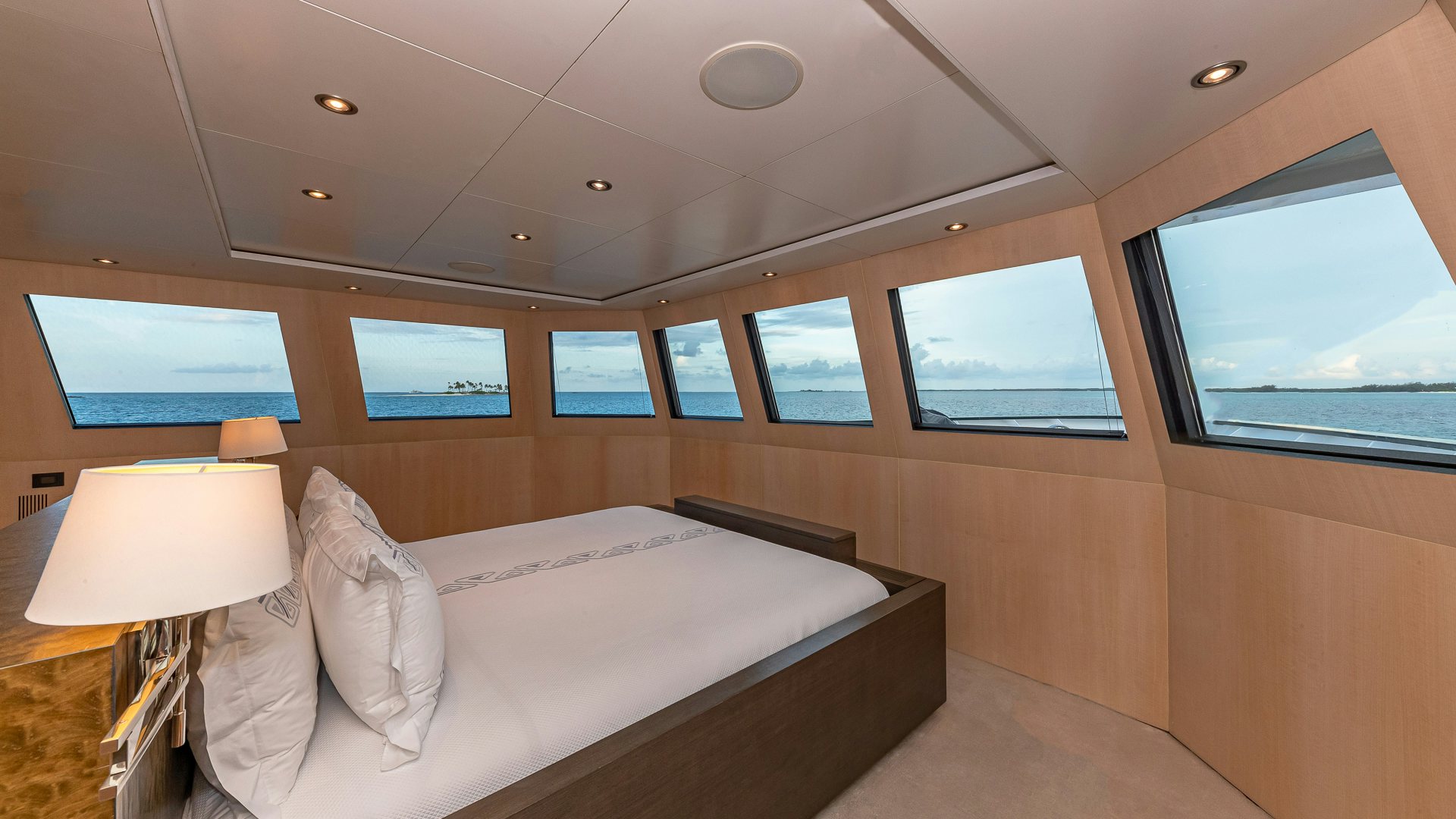 a room with a bed and a window aboard HIGHLANDER Yacht for Charter