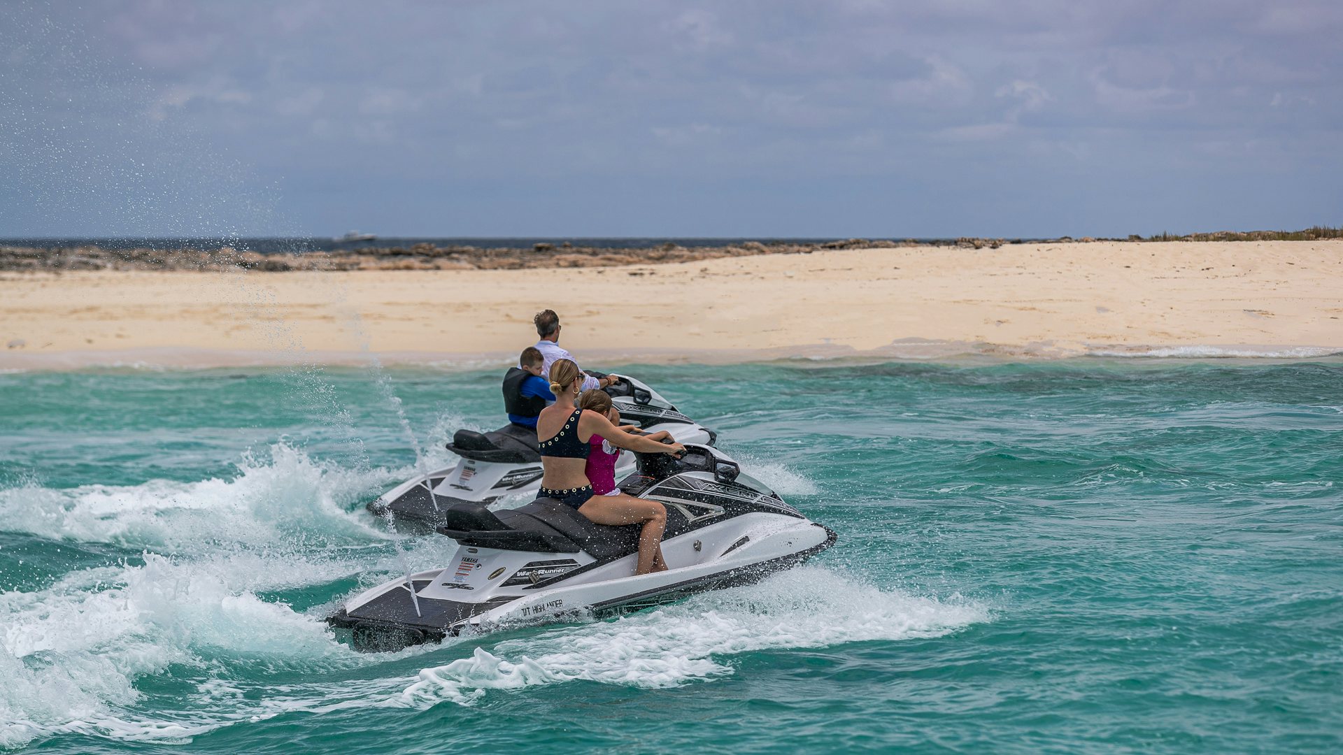 a group of people riding a jet ski on a beach aboard HIGHLANDER Yacht for Charter