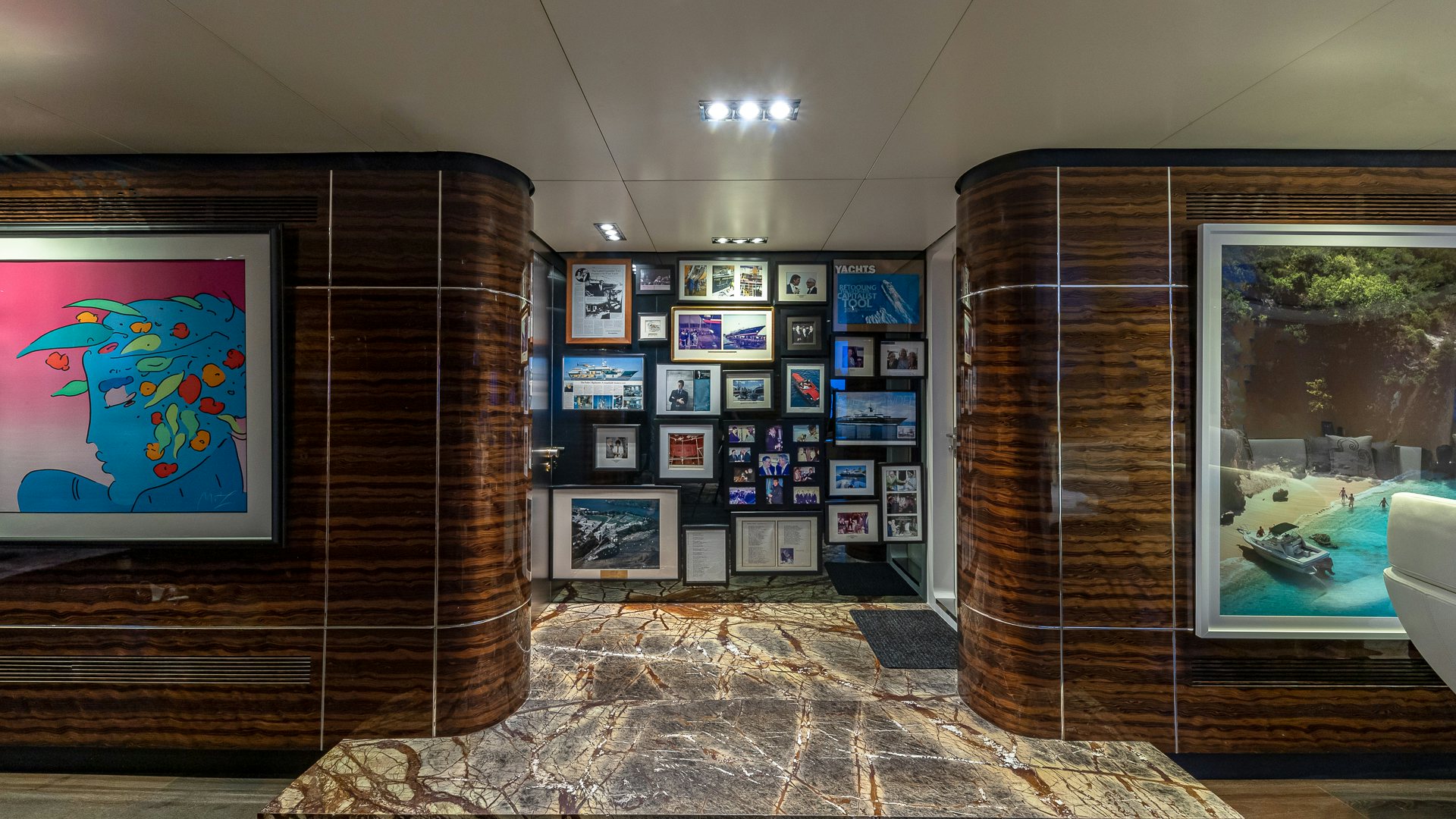 a room with a wall of posters and pictures on the wall aboard HIGHLANDER Yacht for Charter