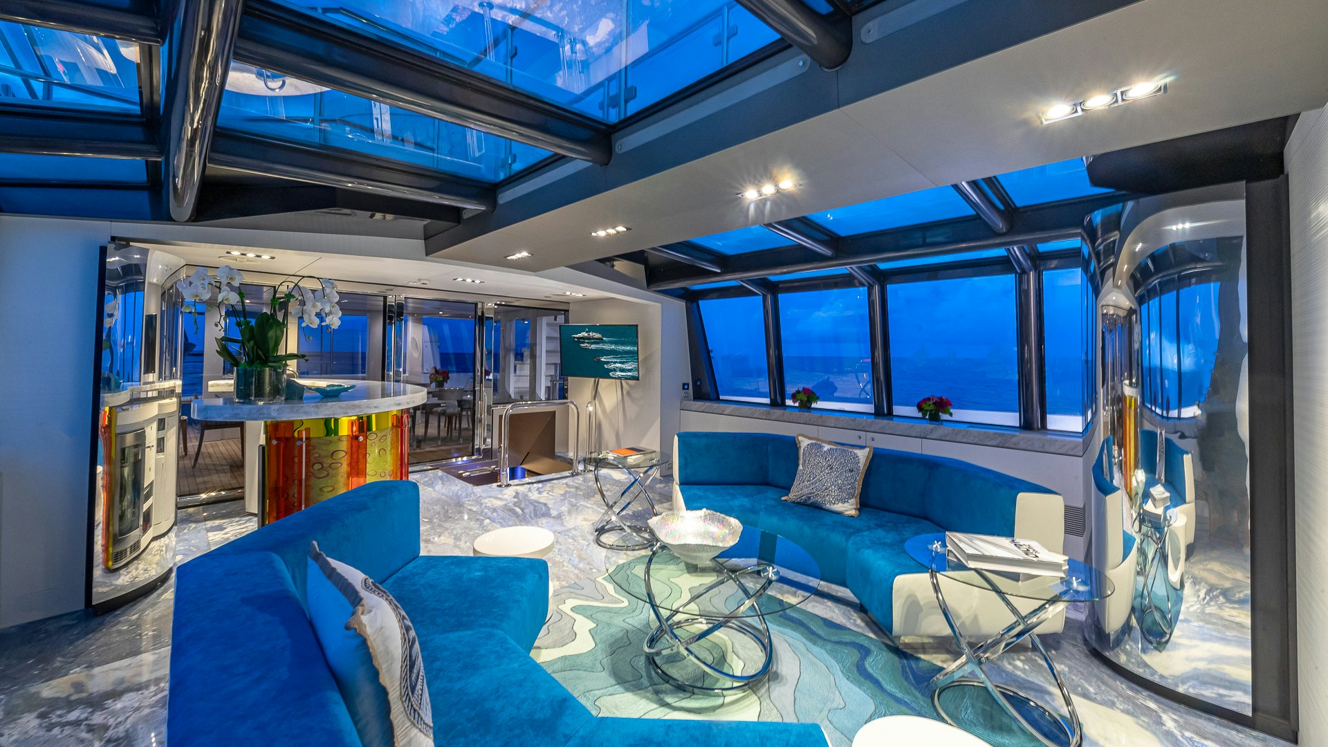 a room with a blue couch and a table with a blue couch aboard HIGHLANDER Yacht for Charter