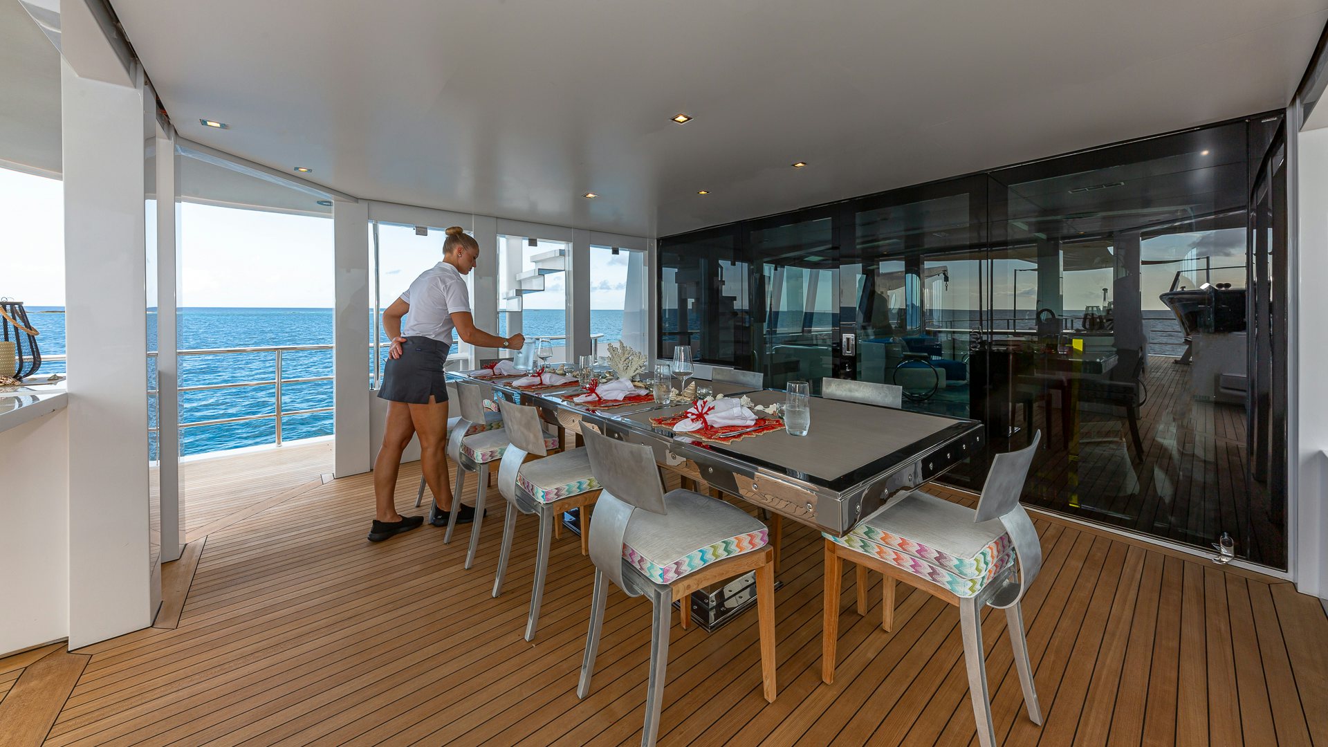 a person standing in a room with a table and chairs aboard HIGHLANDER Yacht for Charter