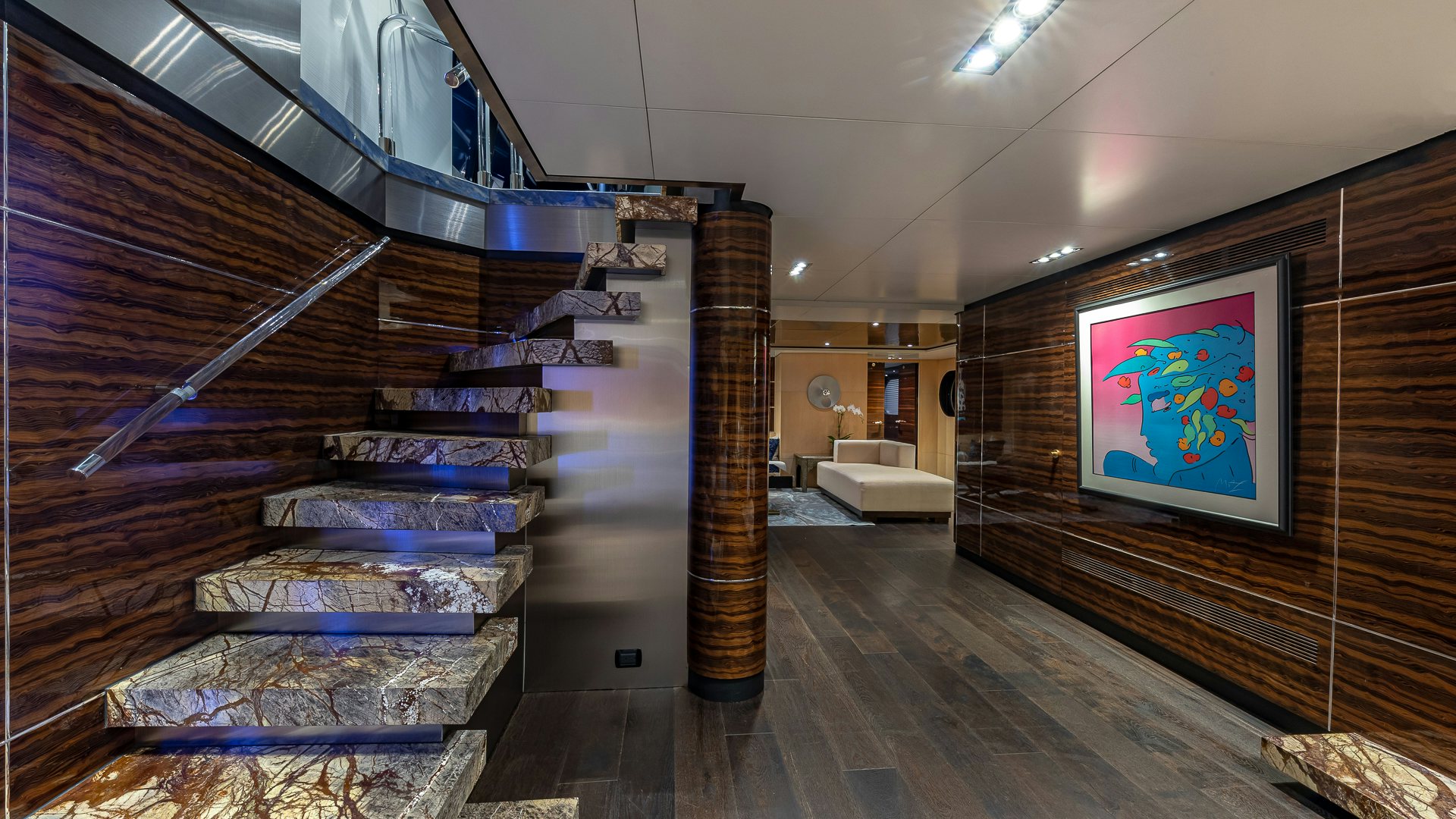 a room with a staircase and a painting on the wall aboard HIGHLANDER Yacht for Charter