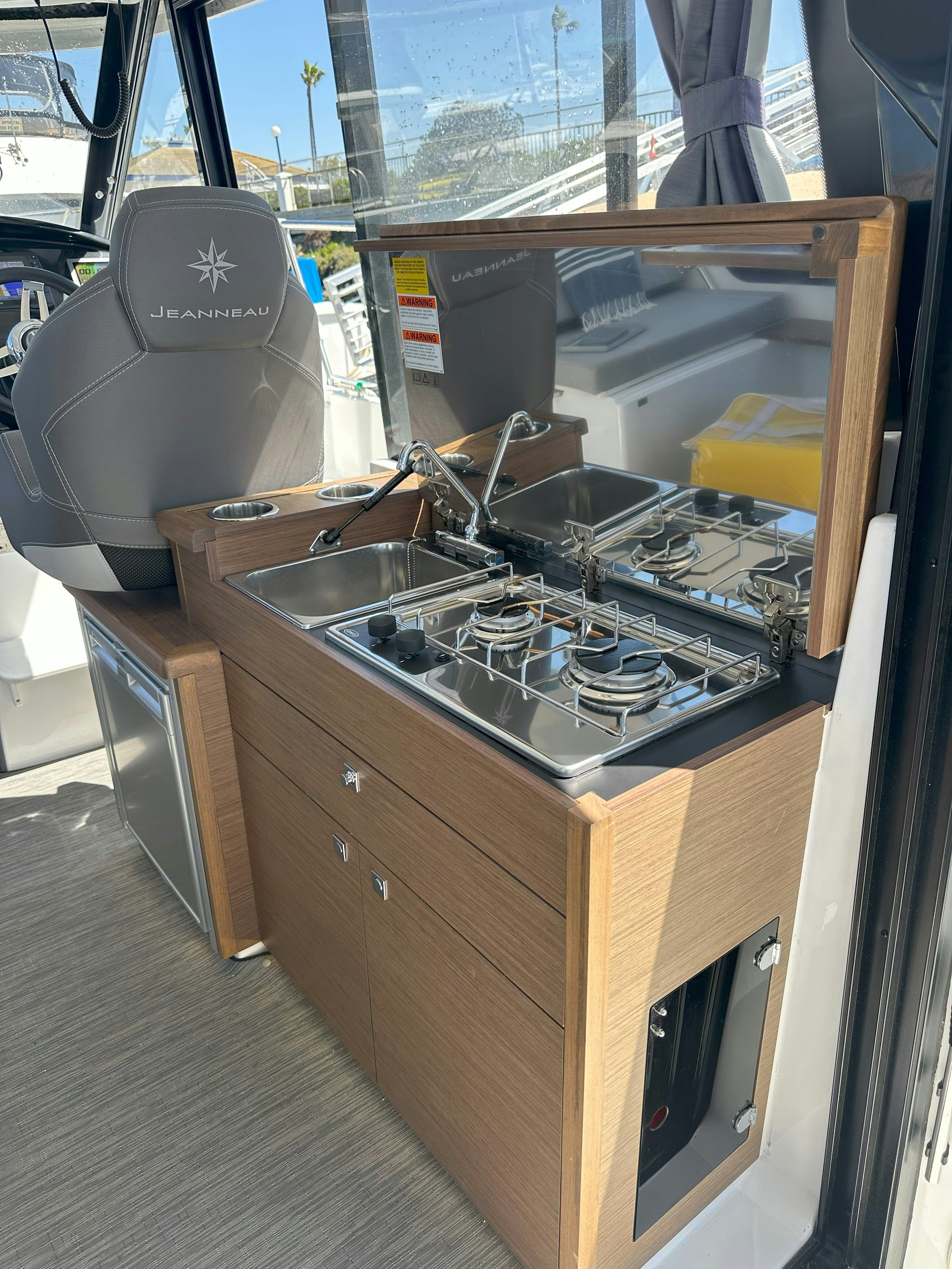 a kitchen with a stove and a window aboard DESTINATION UNKNOWN II Yacht for Sale