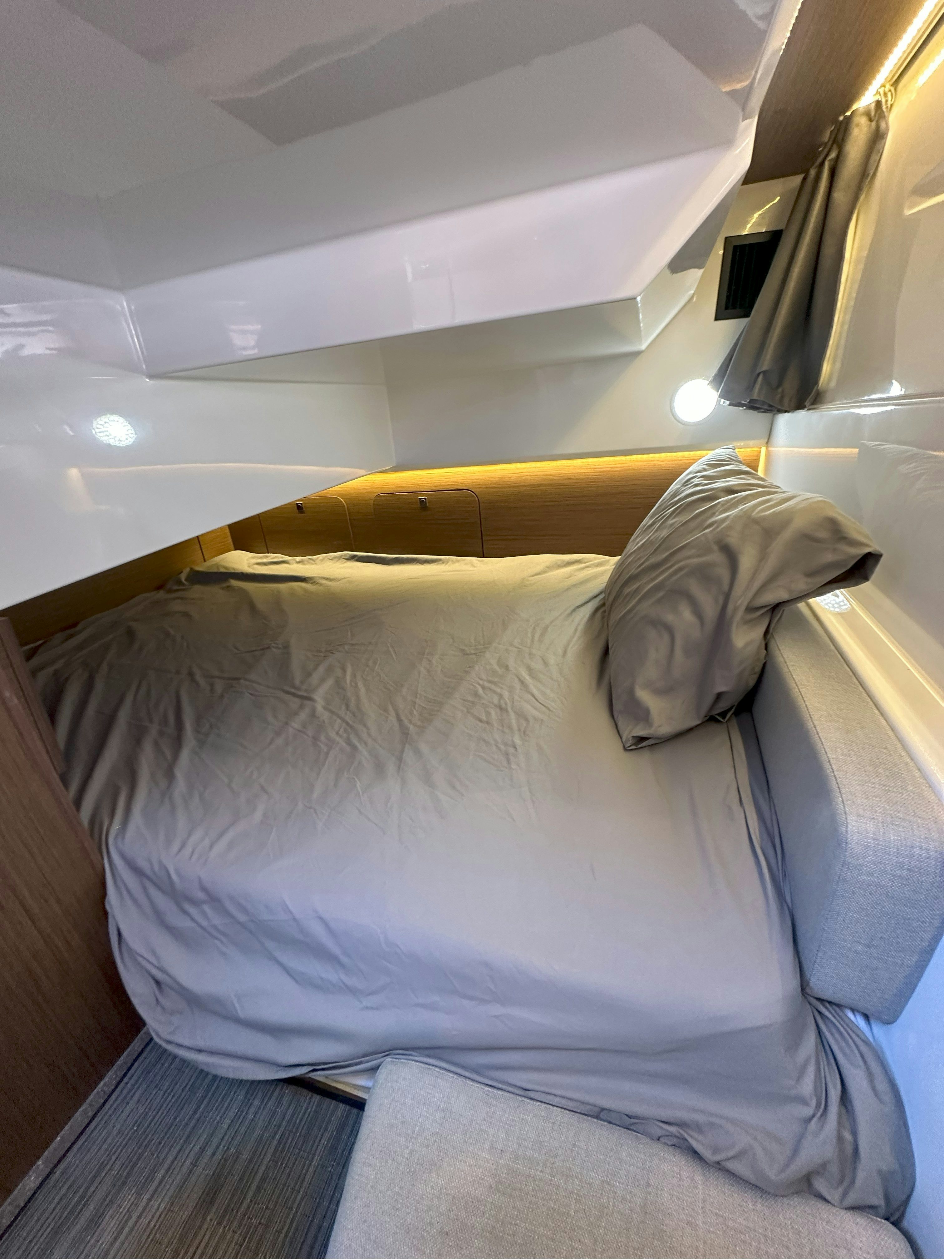 a bed with white sheets aboard DESTINATION UNKNOWN II Yacht for Sale