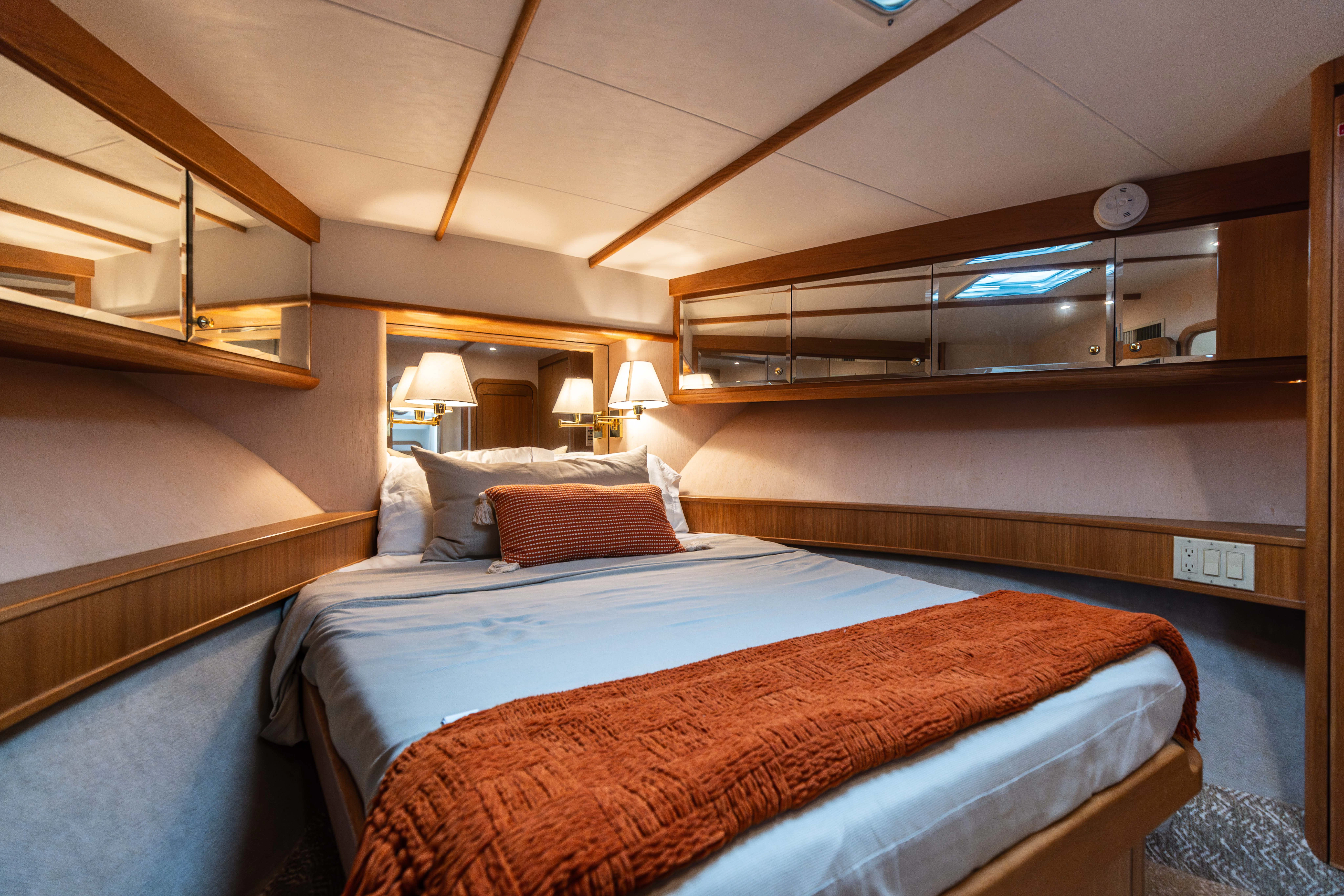 a bed with a blue sheet aboard 3TEN Yacht for Sale