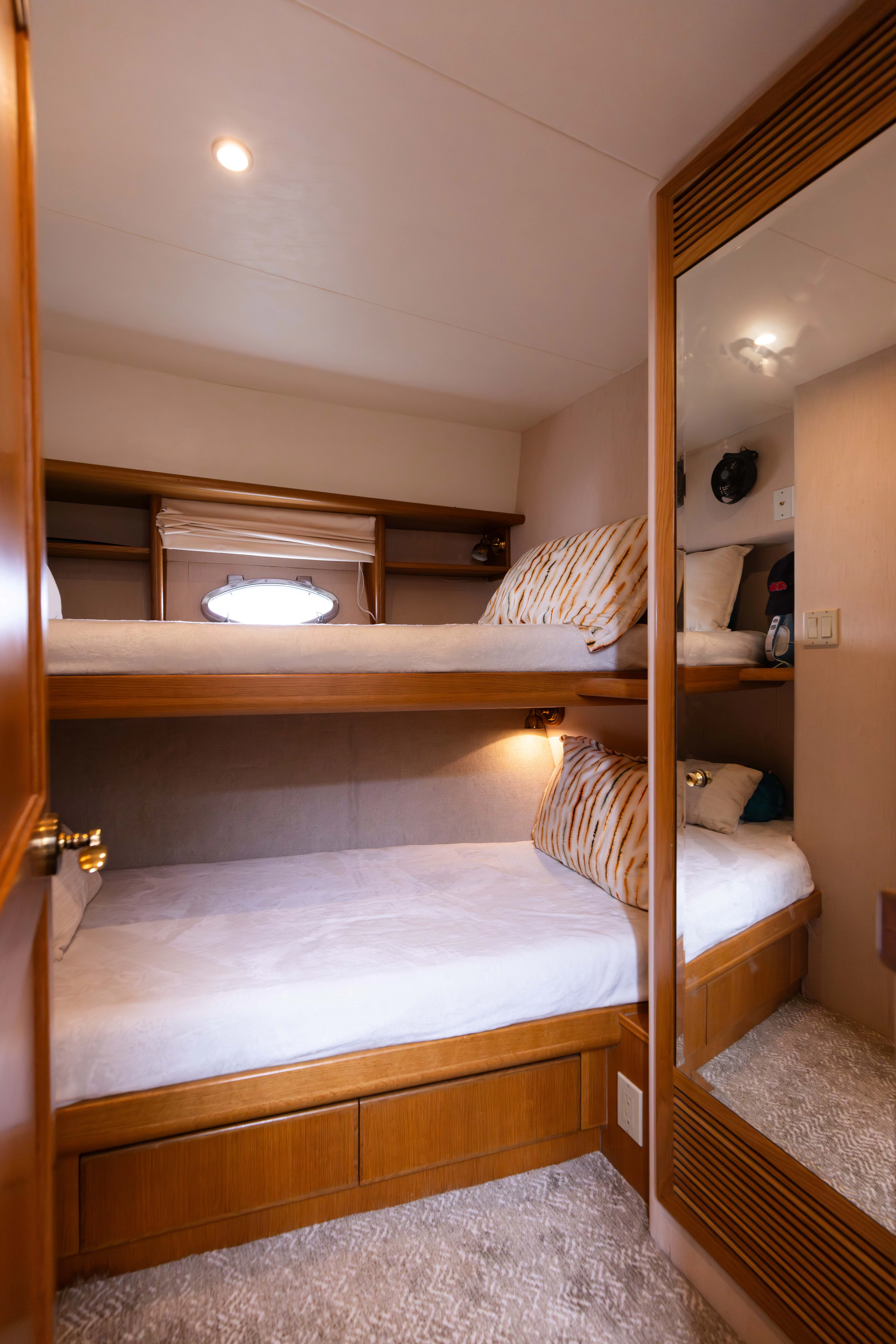 a bunk bed with a wood headboard aboard 3TEN Yacht for Sale