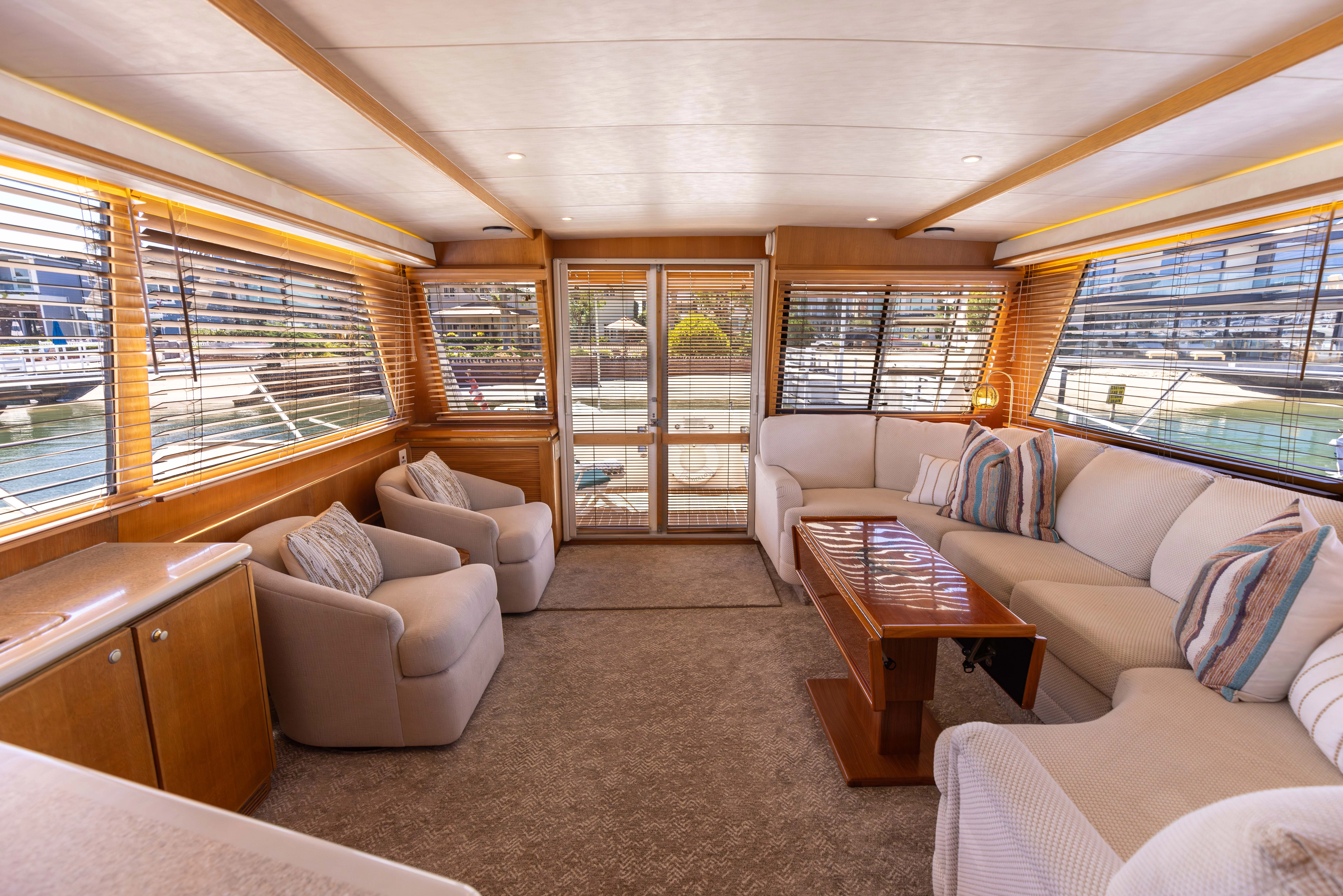 a living room with a large window aboard 3TEN Yacht for Sale