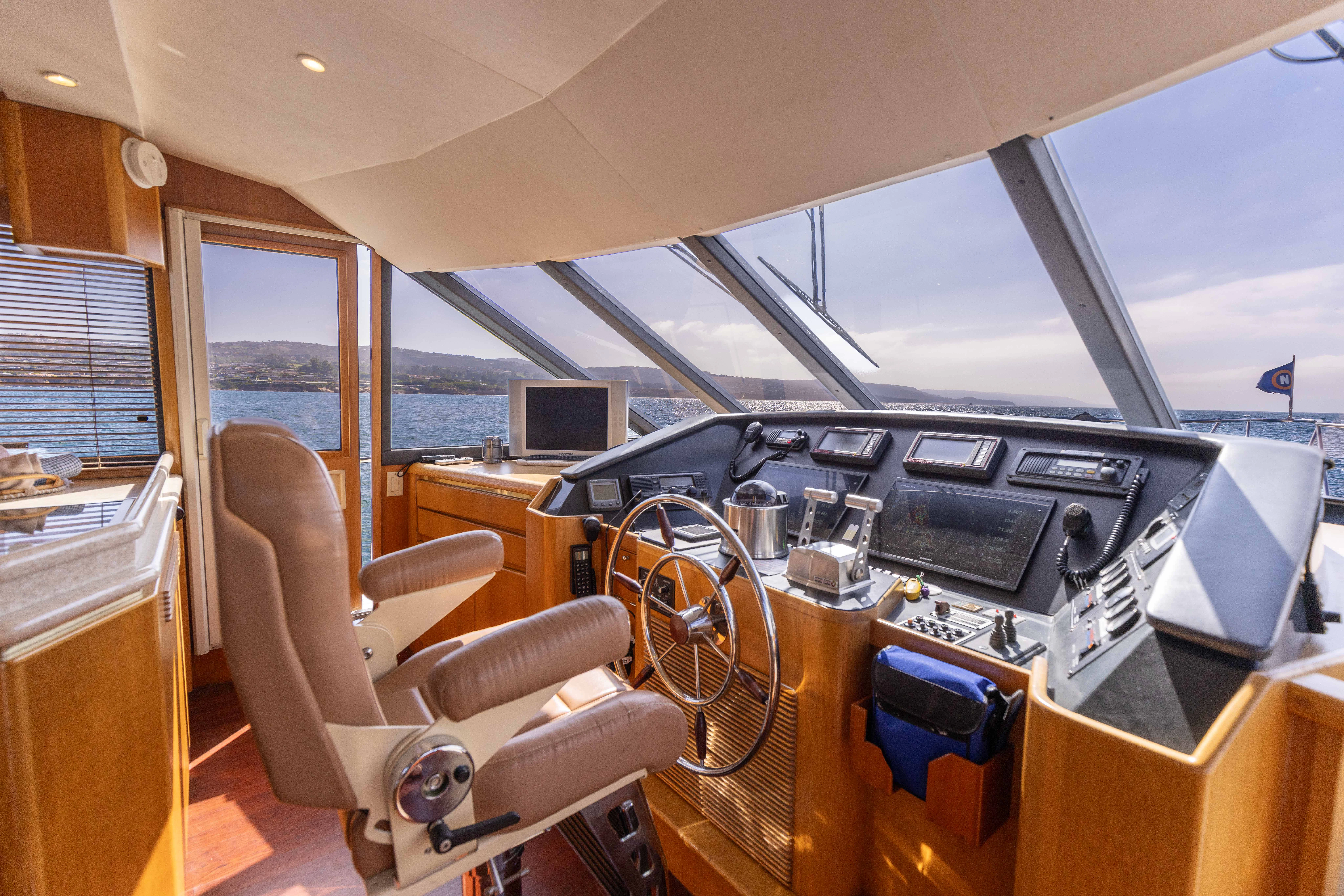 inside of a vehicle with a large window and a desk with a computer and a chair aboard 3TEN Yacht for Sale