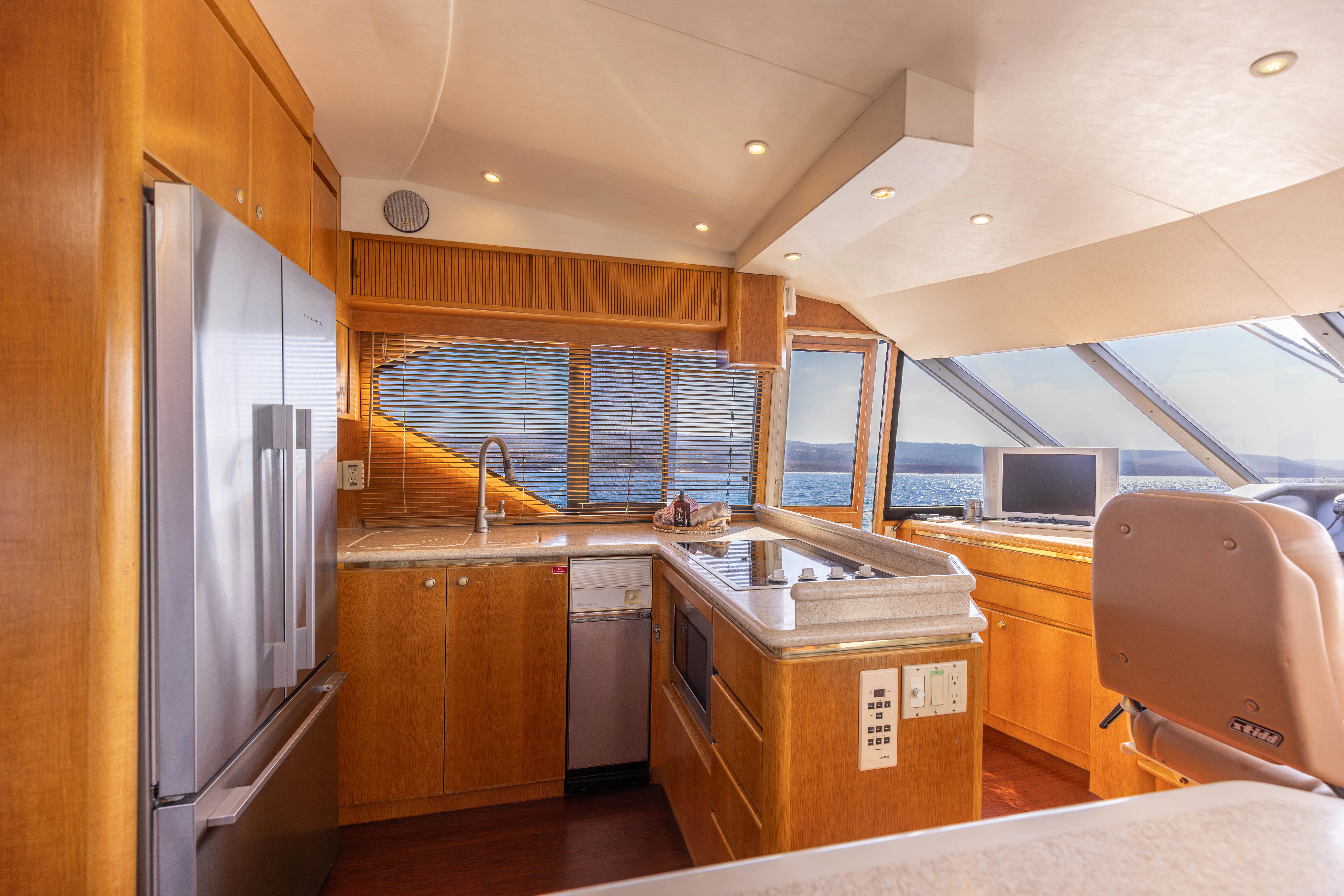 a kitchen with a large refrigerator aboard 3TEN Yacht for Sale