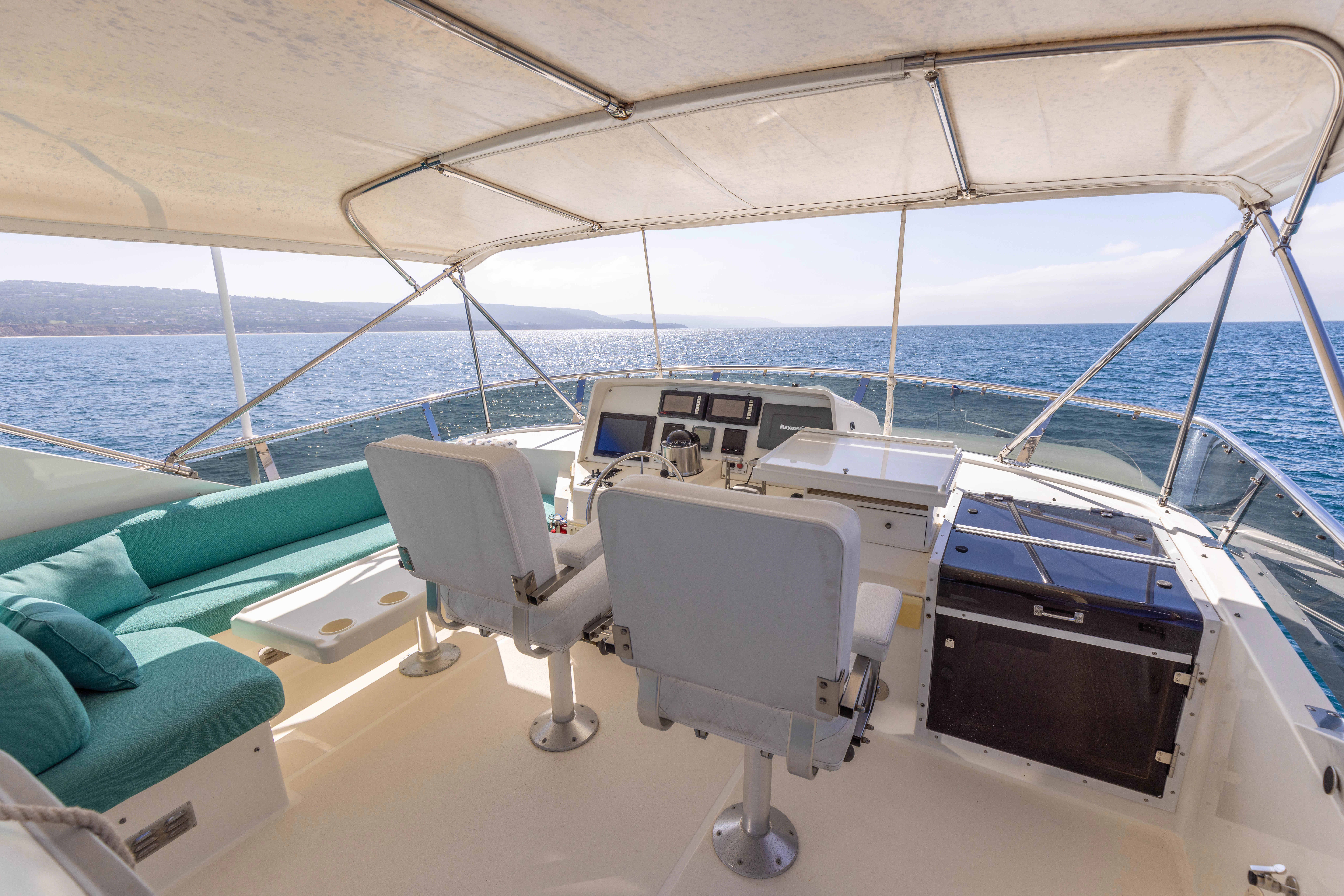 a room with a bed and a chair on a boat aboard 3TEN Yacht for Sale