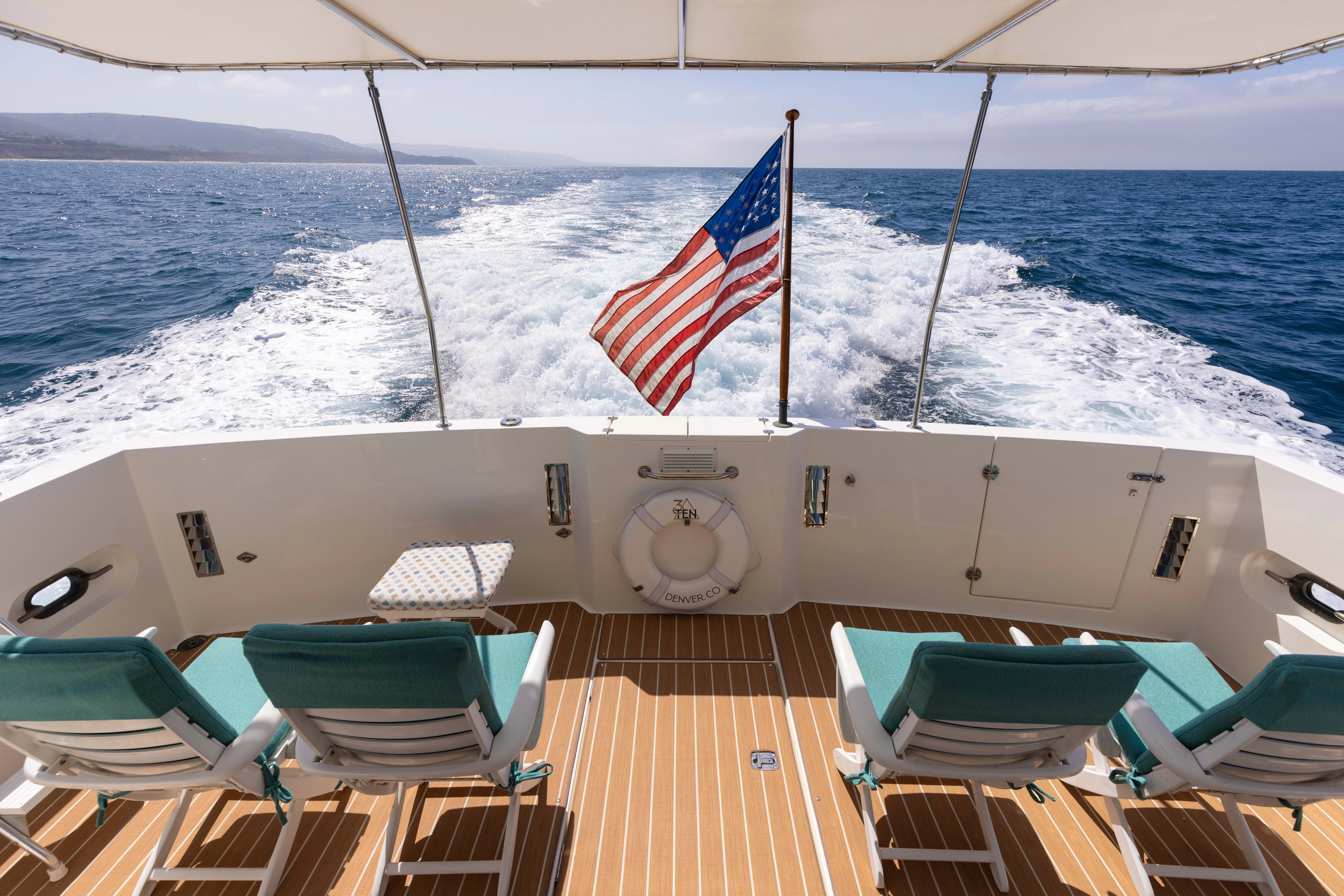 a boat with a flag on the front aboard 3TEN Yacht for Sale
