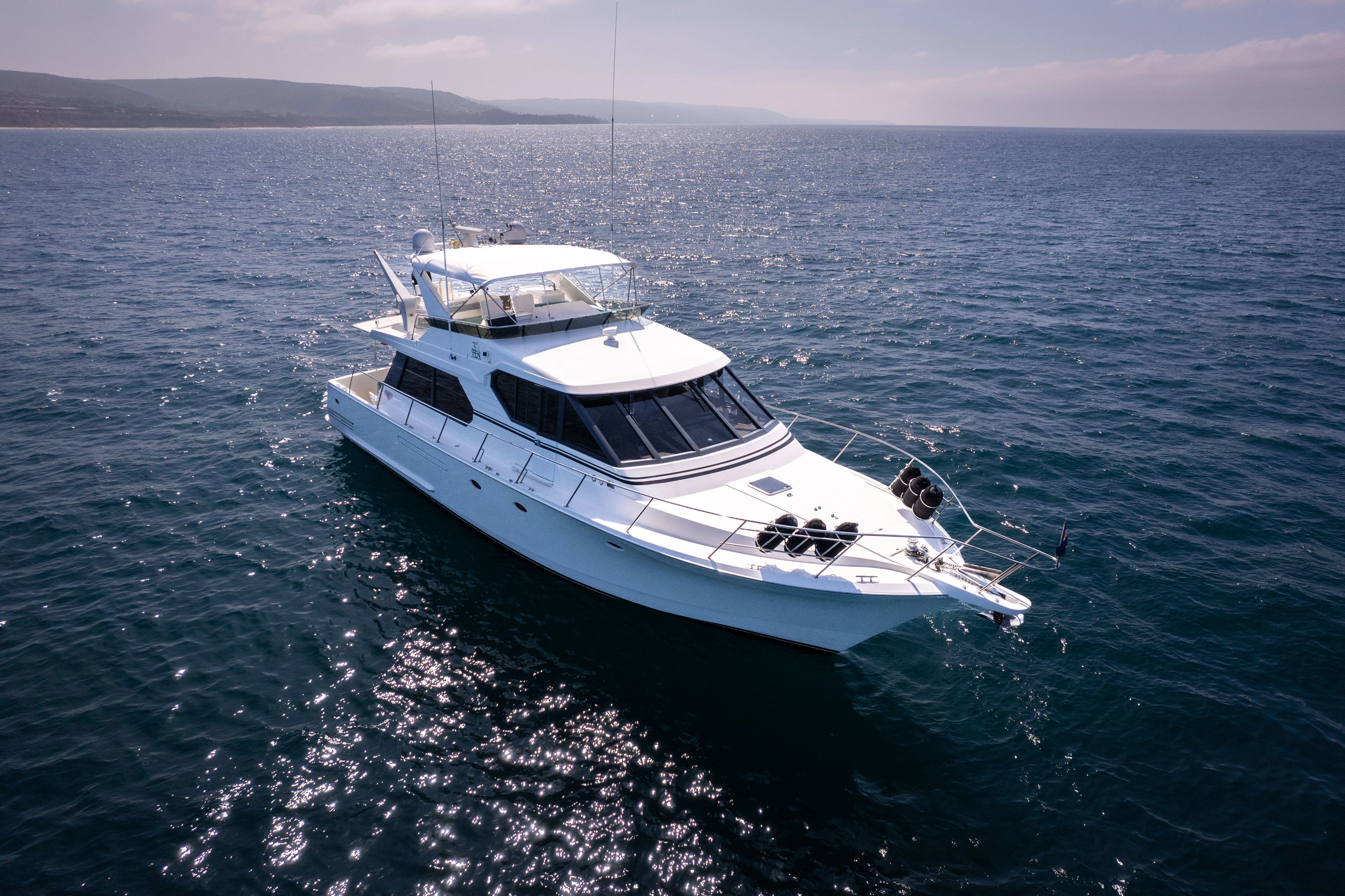 a white boat in the water aboard 3TEN Yacht for Sale