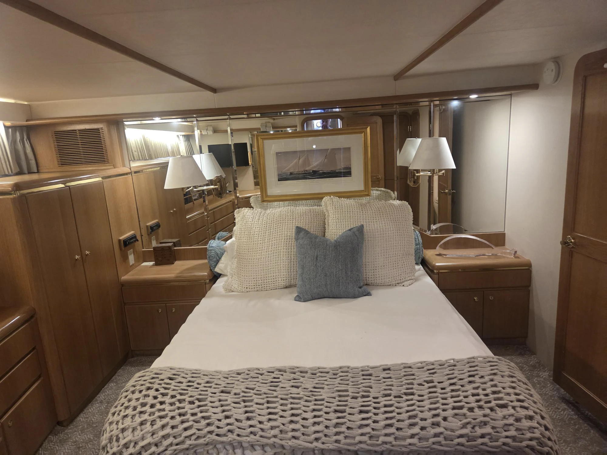a bed with a white and black blanket and pillows aboard 3TEN Yacht for Sale