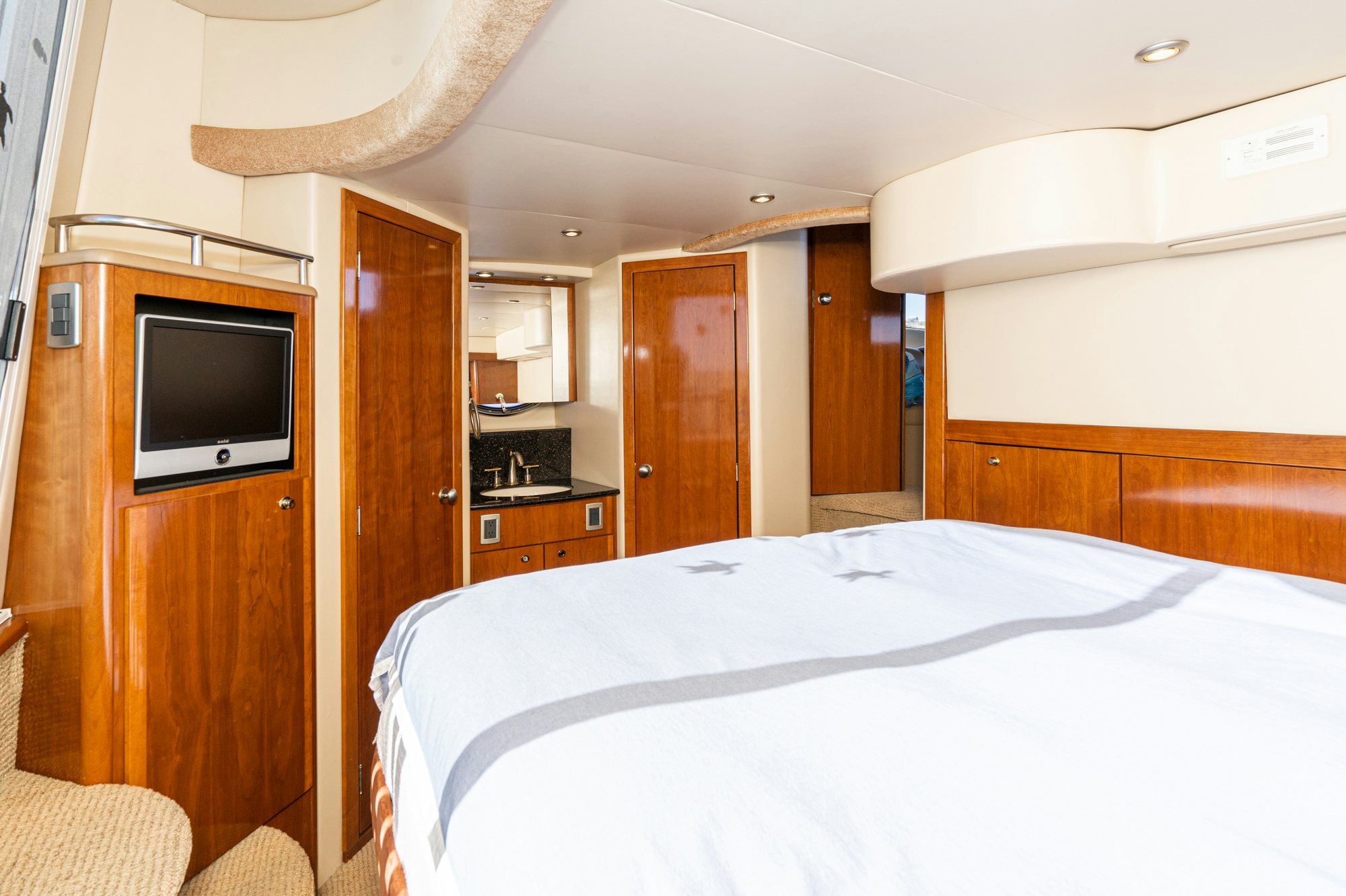 a bedroom with a tv and a bed aboard THE SEA IS FOR ME Yacht for Sale