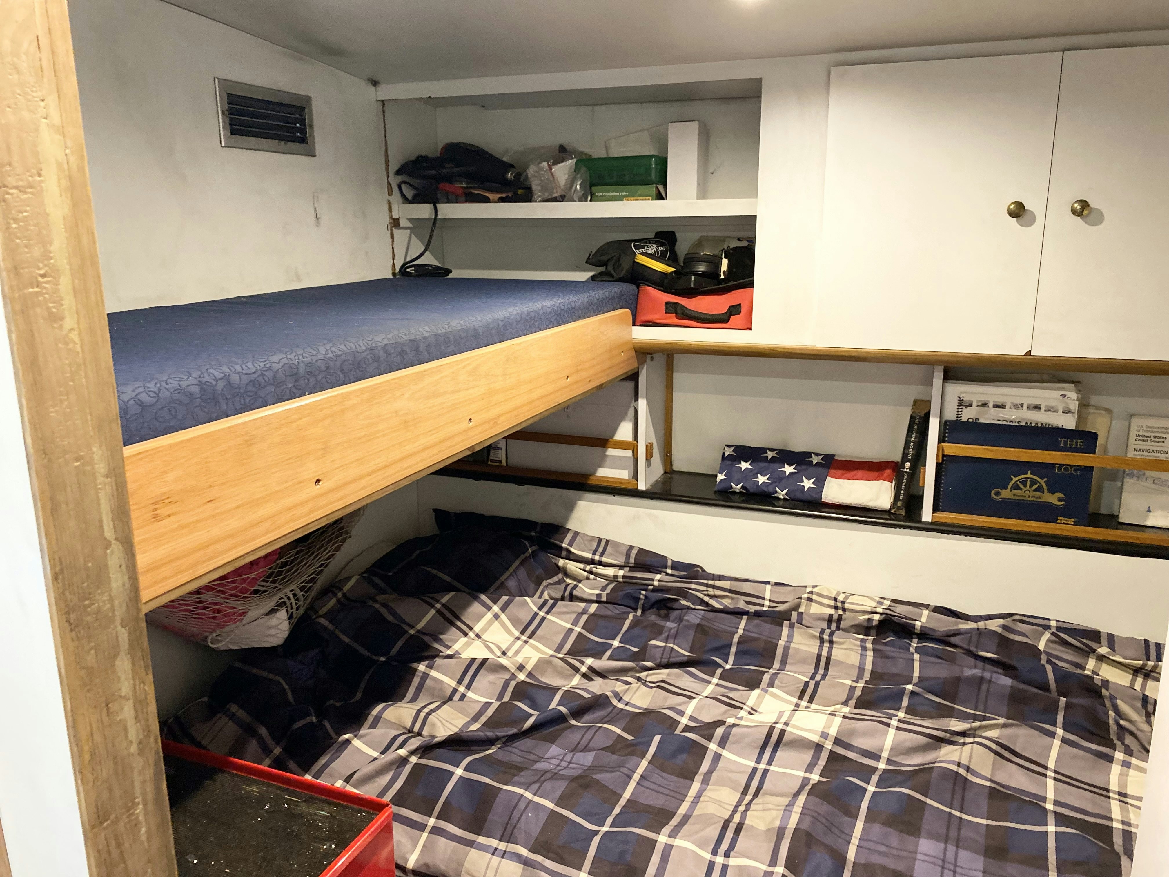 a room with a bed and a shelf with objects on it aboard SUITE LIFE Yacht for Sale