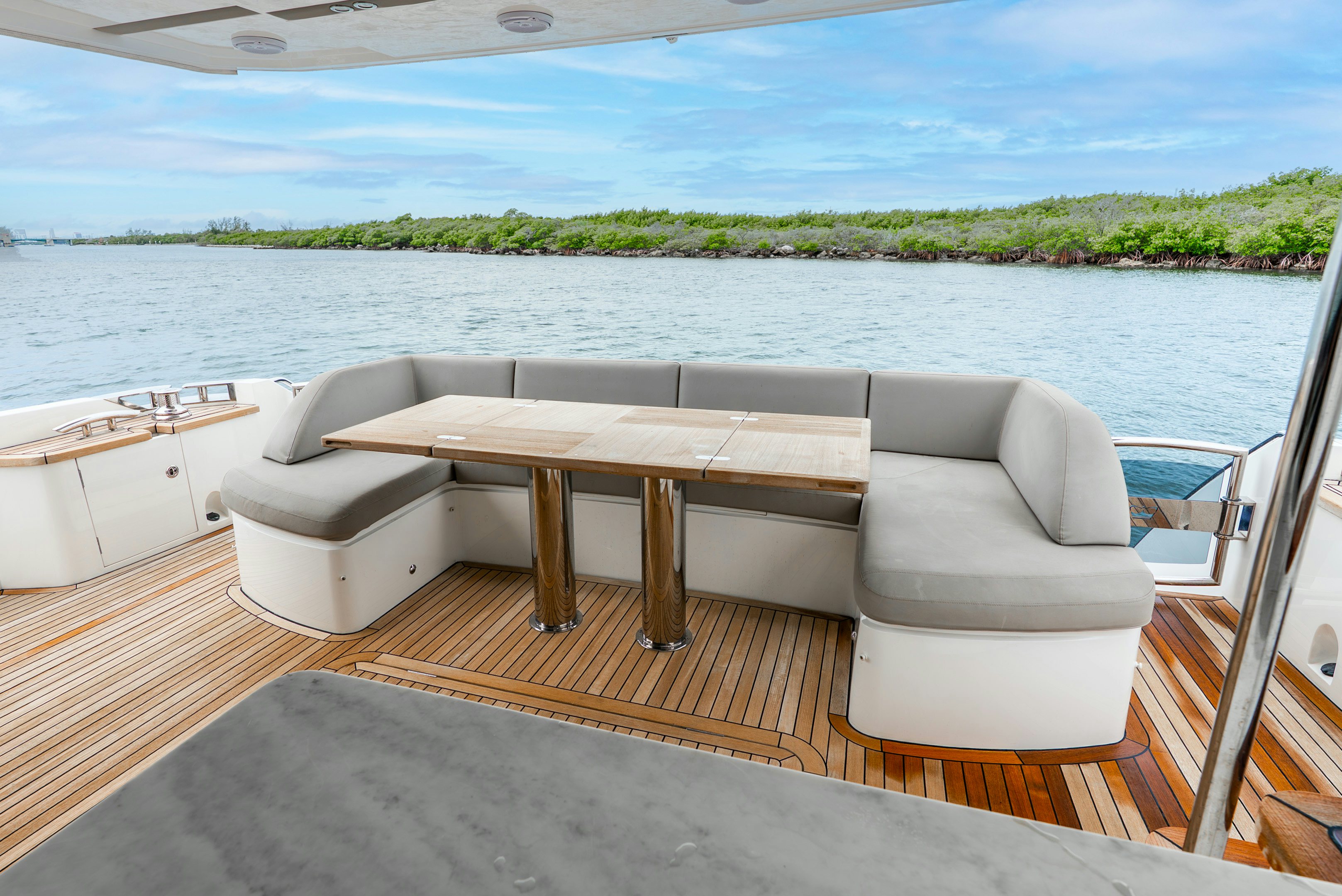 a table and chairs on a deck overlooking a body of water aboard MAMU Yacht for Sale
