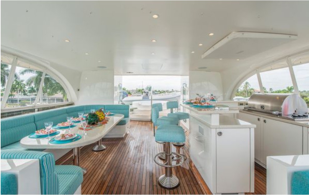 a kitchen with a dining table and chairs aboard HOMECOMING Yacht for Sale