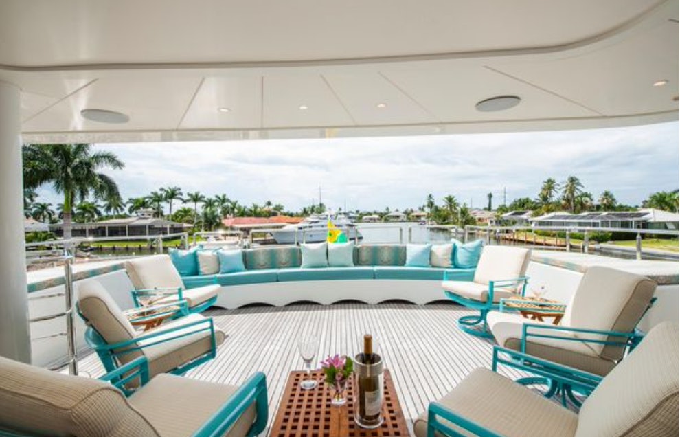 a pool with lounge chairs and a deck with a view of the water aboard HOMECOMING Yacht for Sale