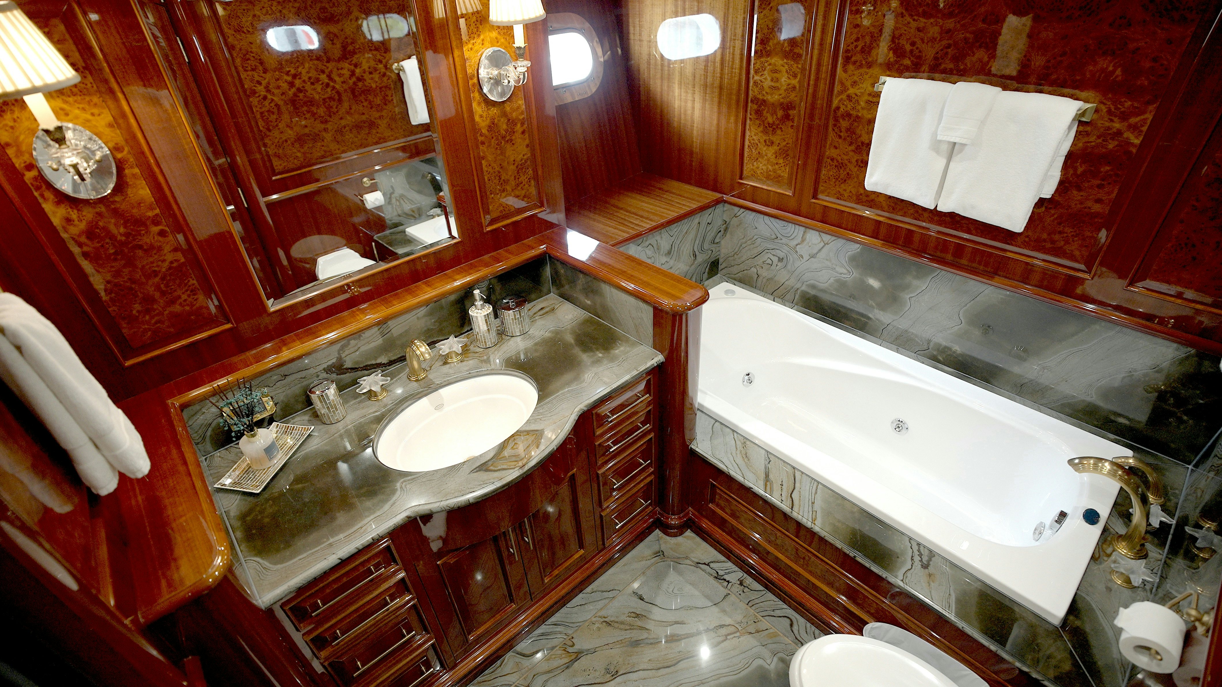 a bathroom with a large bathtub and sinks aboard HOMECOMING Yacht for Sale