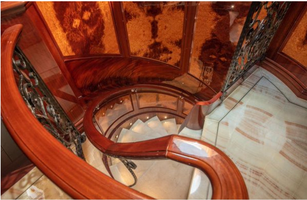 a wooden staircase with a glass window aboard HOMECOMING Yacht for Sale