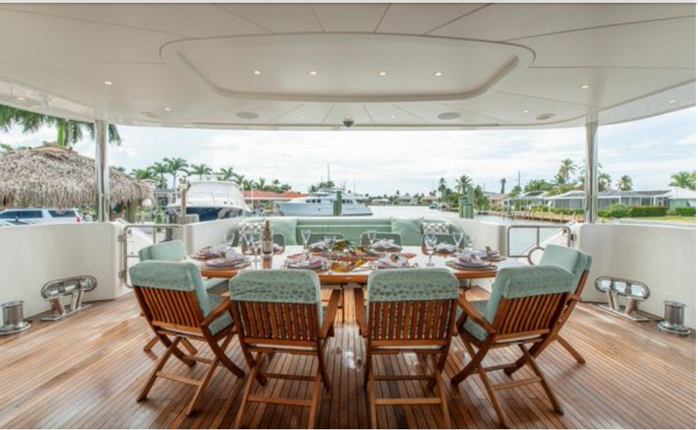 a table with chairs and a pool aboard HOMECOMING Yacht for Sale
