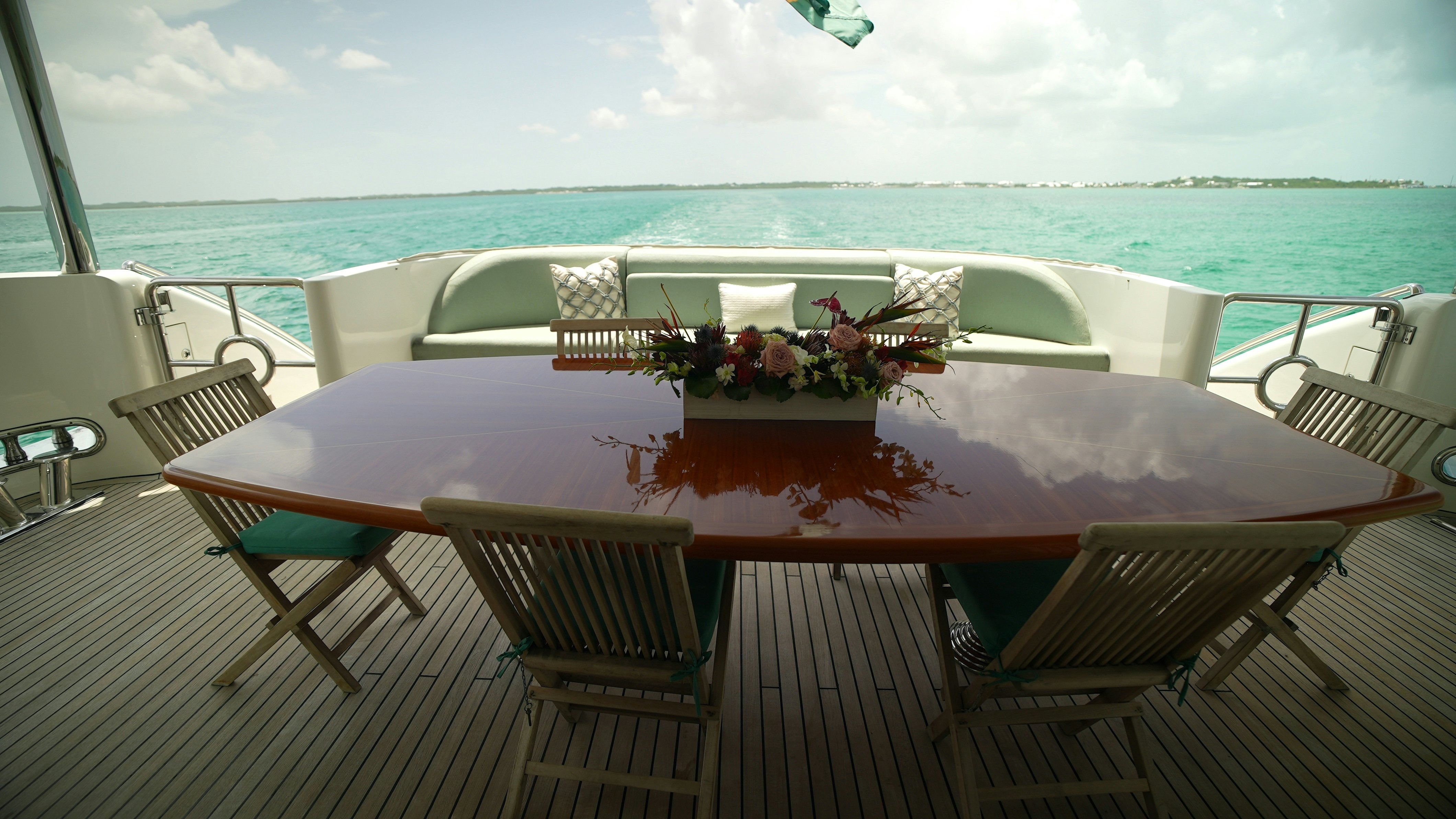 a table with chairs on it next to a body of water aboard HOMECOMING Yacht for Sale
