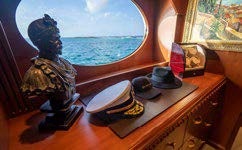 a window with a painting of a sea and a person sitting on a chair aboard RELENTLESS Yacht for Charter