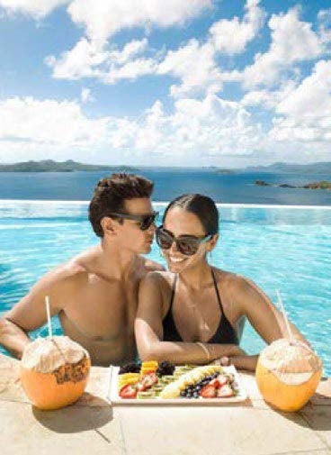 a man and woman sitting at a table with food on it aboard RELENTLESS Yacht for Charter