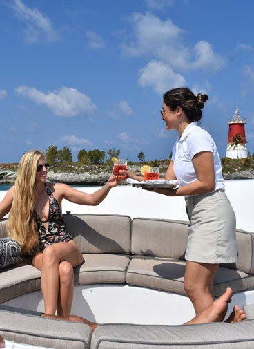a woman and a man sitting on a ledge eating food aboard RELENTLESS Yacht for Charter