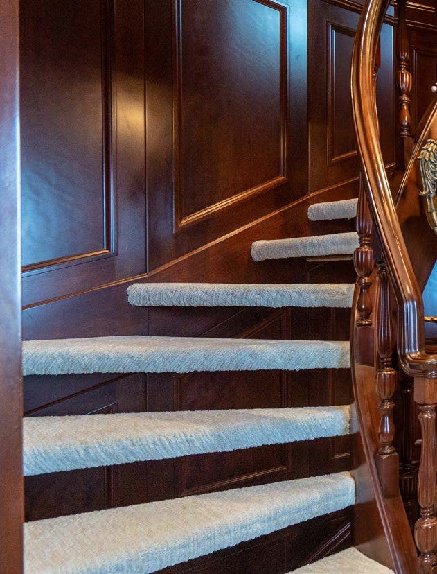 a staircase with a blue and white striped rug aboard RELENTLESS Yacht for Charter