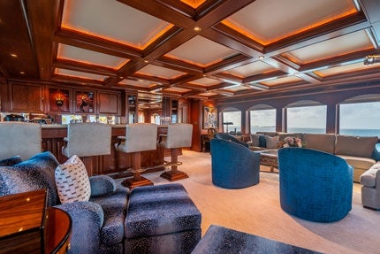 a room with a blue couch and a blue chair aboard RELENTLESS Yacht for Charter