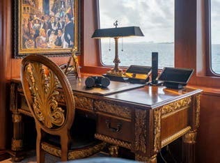 a desk with a chair and a lamp on it aboard RELENTLESS Yacht for Charter