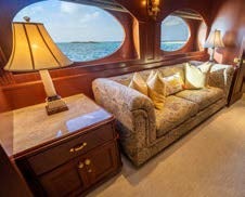 a room with a couch and a large mirror aboard RELENTLESS Yacht for Charter