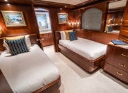 a room with a bed and a couch aboard RELENTLESS Yacht for Charter