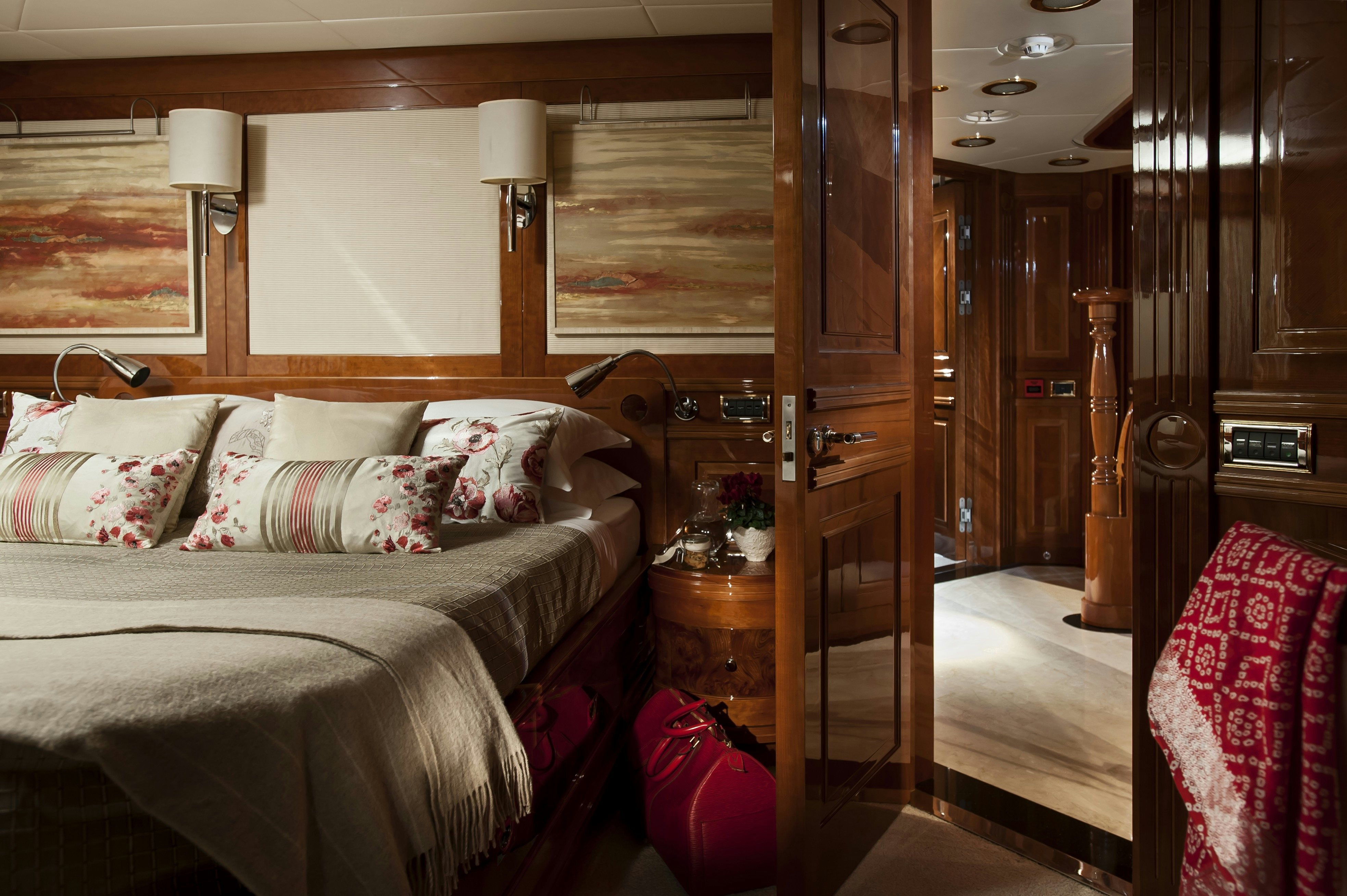 a bedroom with a bed and a mirror aboard METSUYAN IV Yacht for Charter