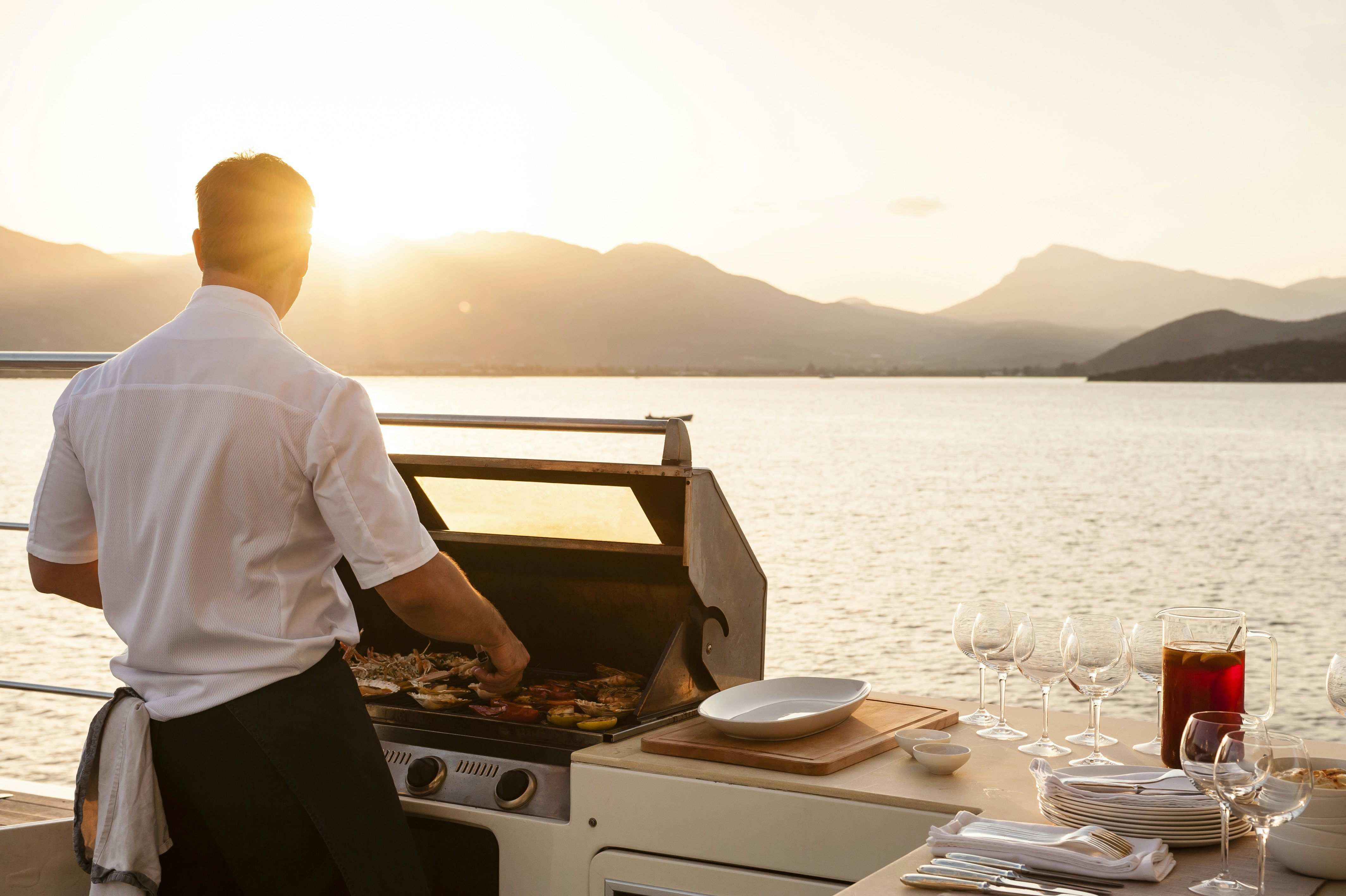 a person grilling food on a boat aboard METSUYAN IV Yacht for Charter