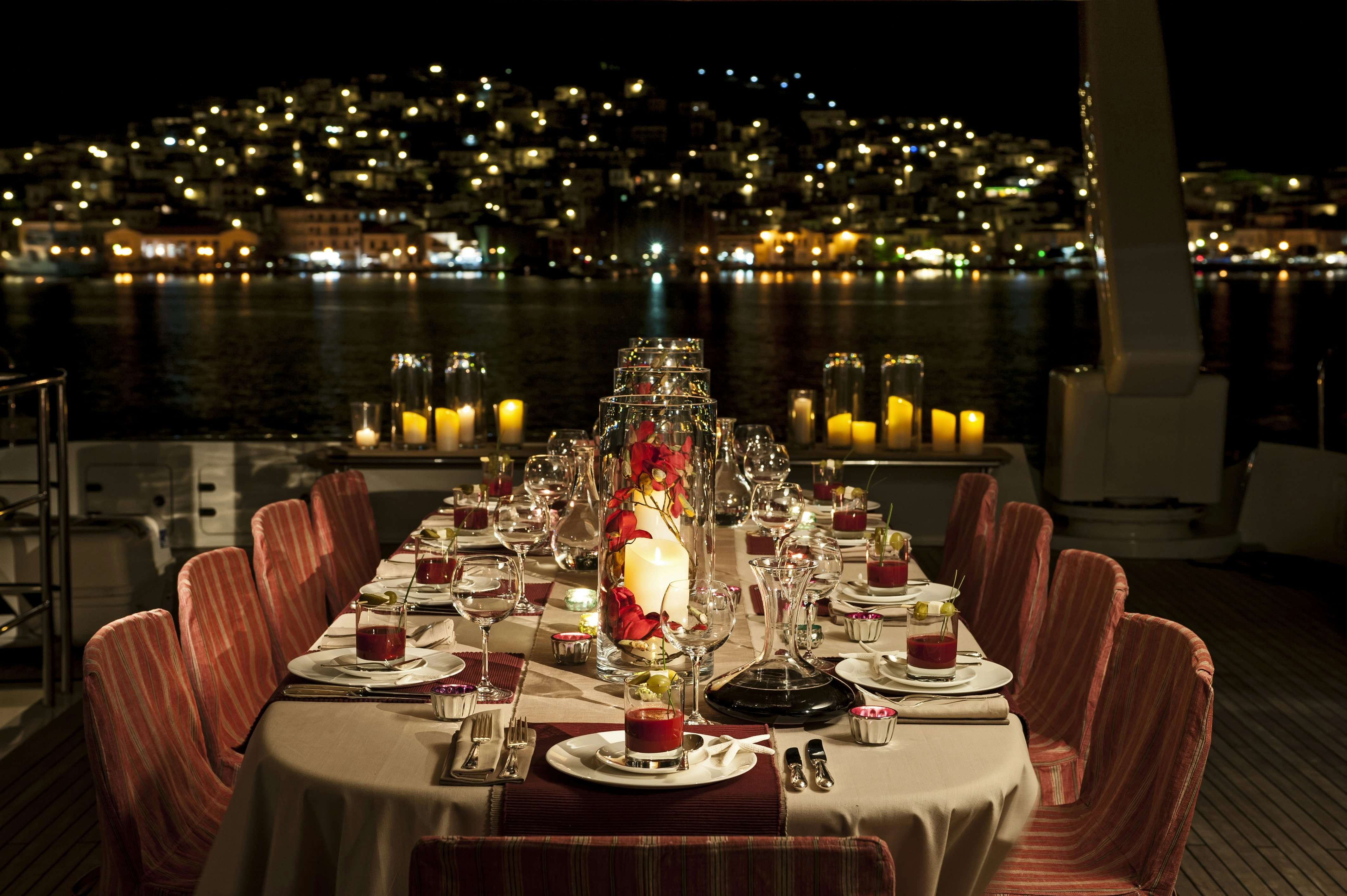 a table set with candles and a view of a city aboard METSUYAN IV Yacht for Charter