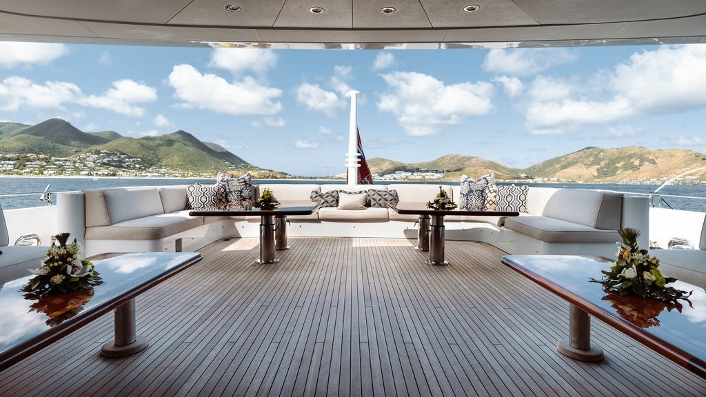 a deck with a table and chairs aboard LADY BETH Yacht for Charter
