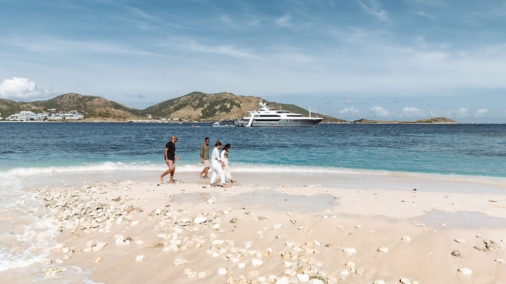 a group of people walking on a beach aboard LADY BETH Yacht for Charter