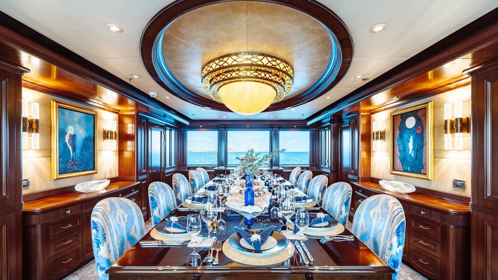 a large dining room with a large chandelier aboard LADY BETH Yacht for Charter