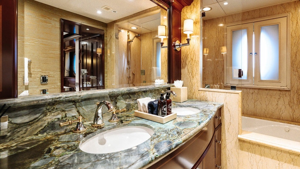 a bathroom with a countertop sink and a large mirror aboard LADY BETH Yacht for Charter