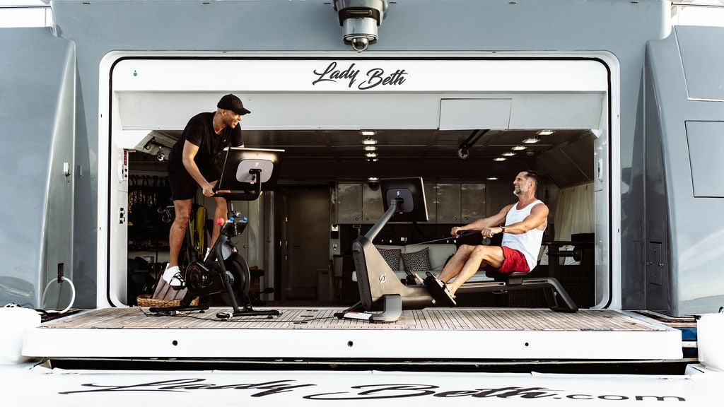 a man and a woman sitting in a vehicle with a camera aboard LADY BETH Yacht for Charter