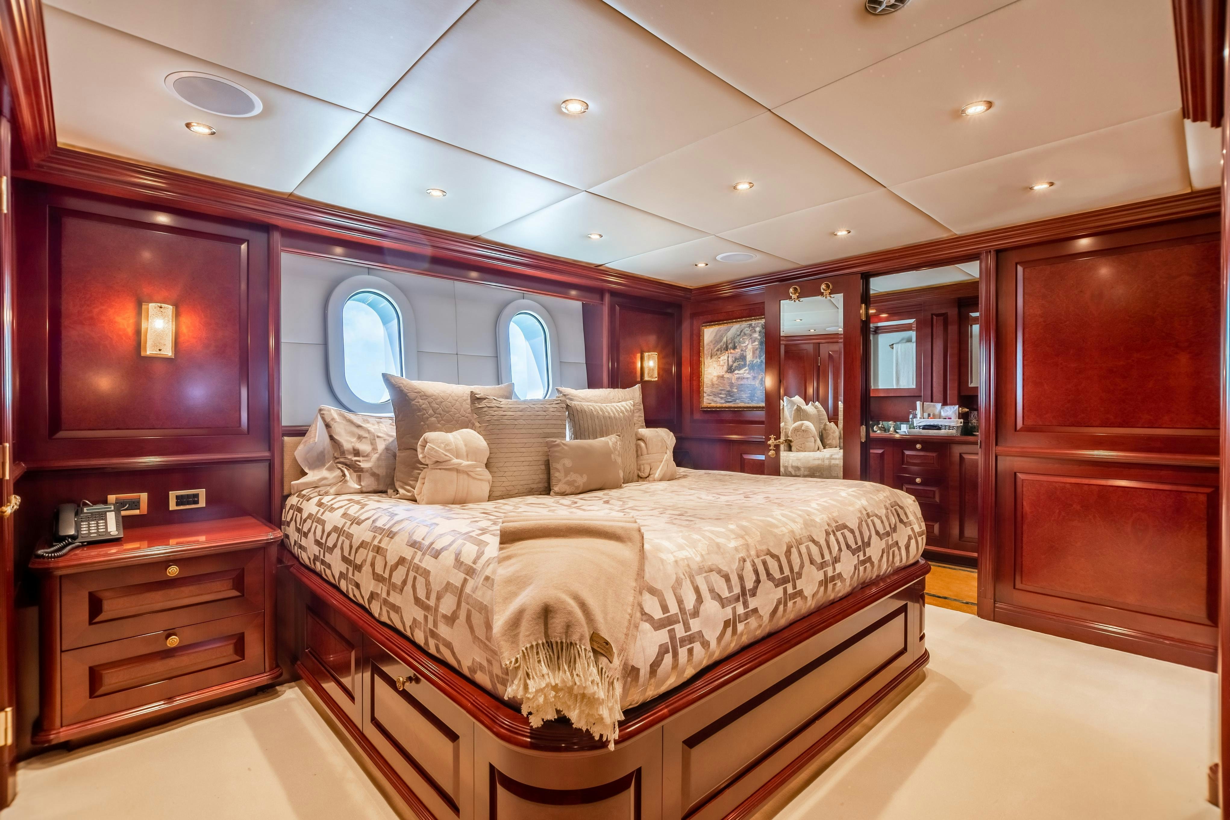 a bedroom with a bed and a dresser aboard TCB Yacht for Charter