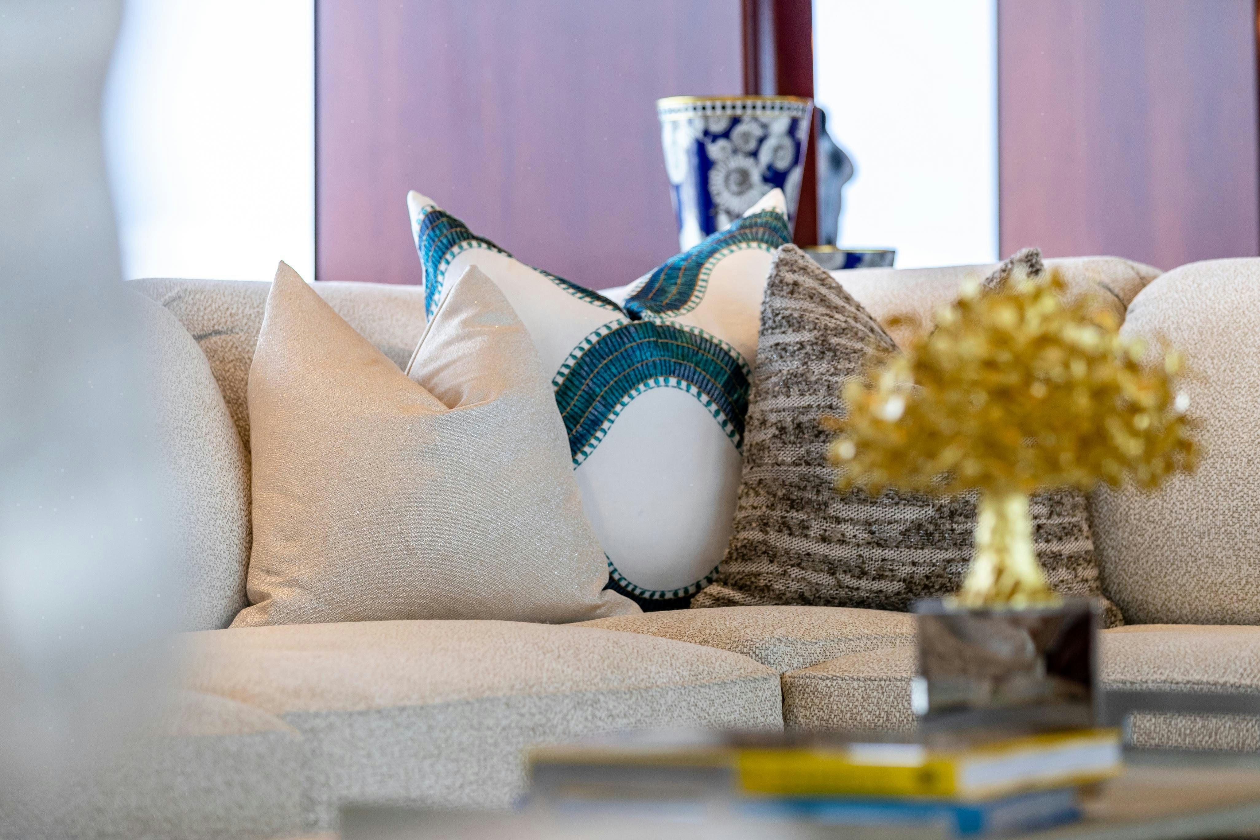 a couch with pillows and a vase on it aboard TCB Yacht for Charter