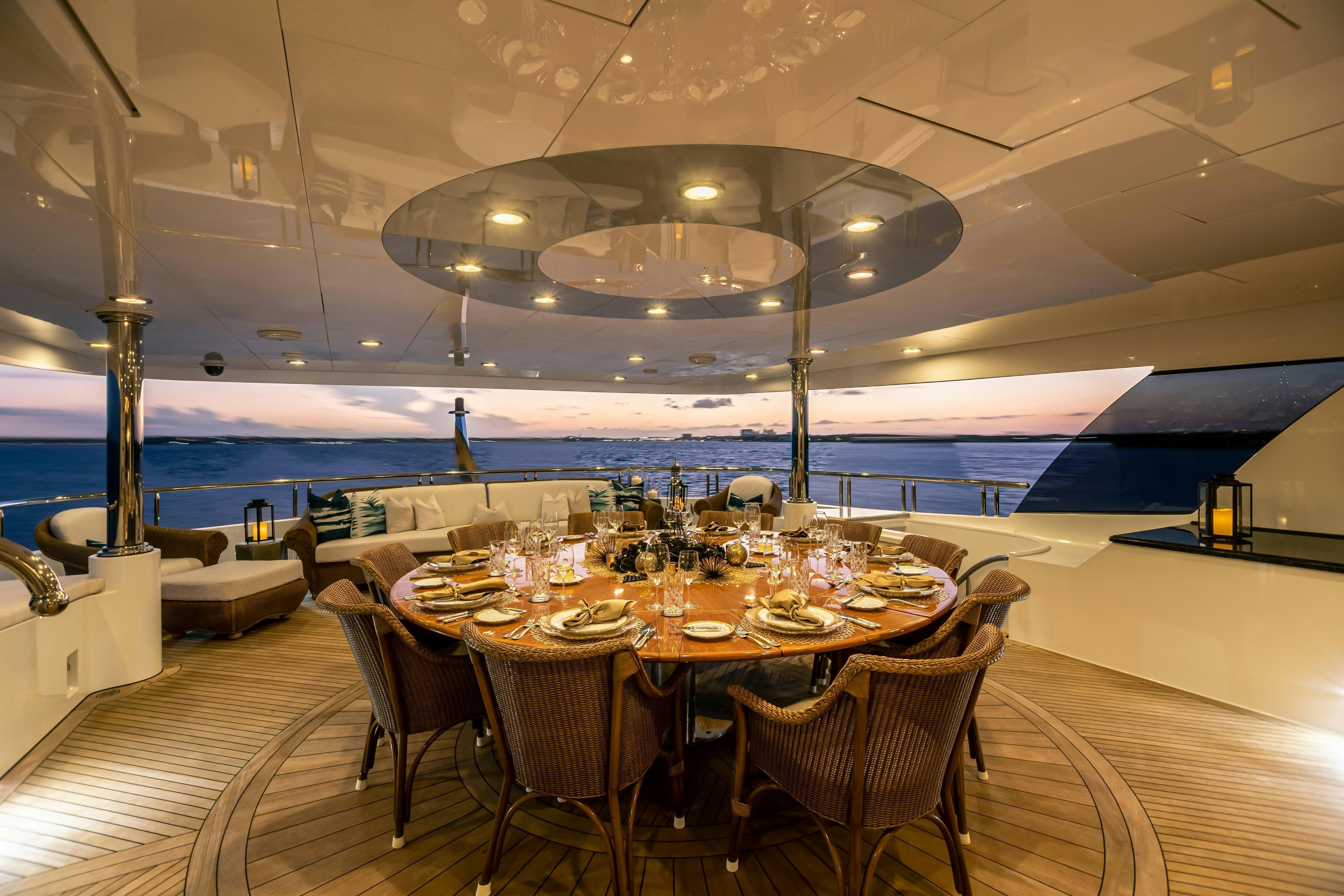 a dining room with a large table set for a dinner party aboard TCB Yacht for Charter