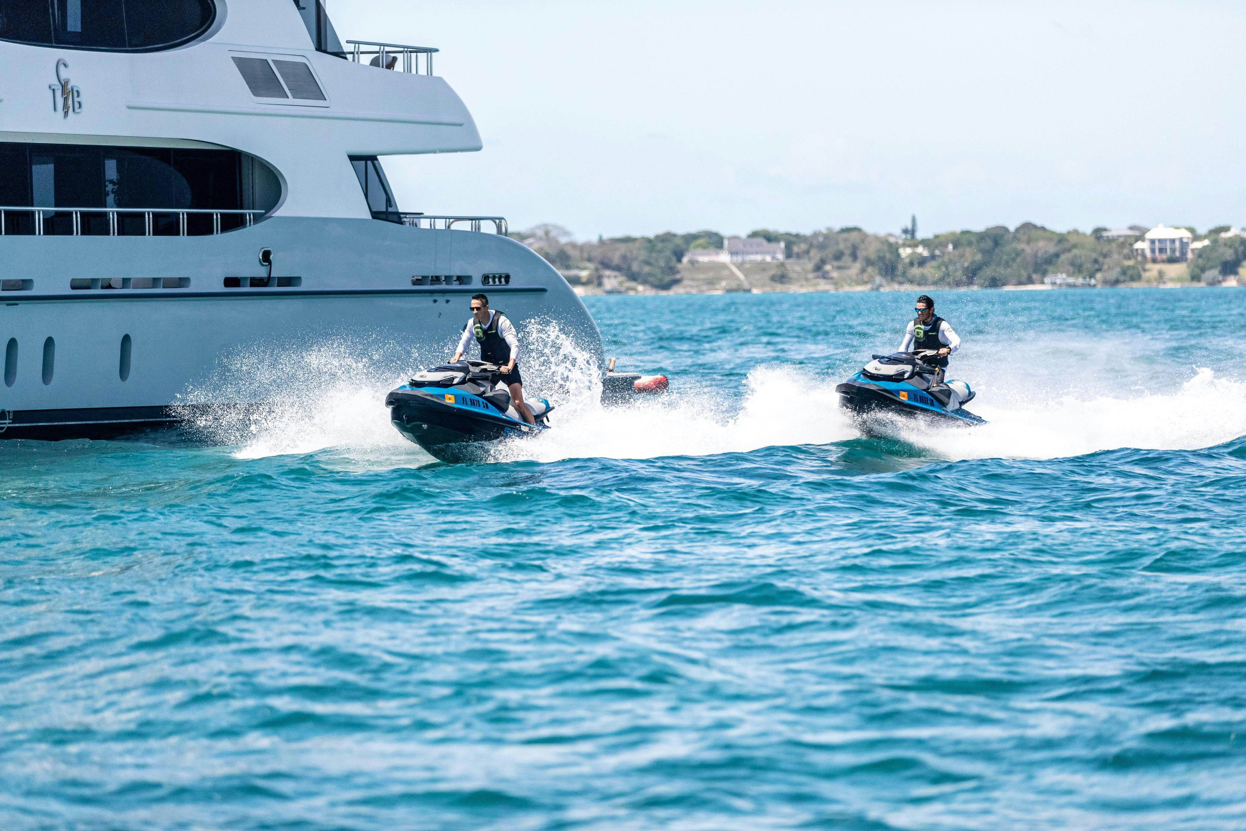 a boat and a couple people on a motorboat in the water aboard TCB Yacht for Charter