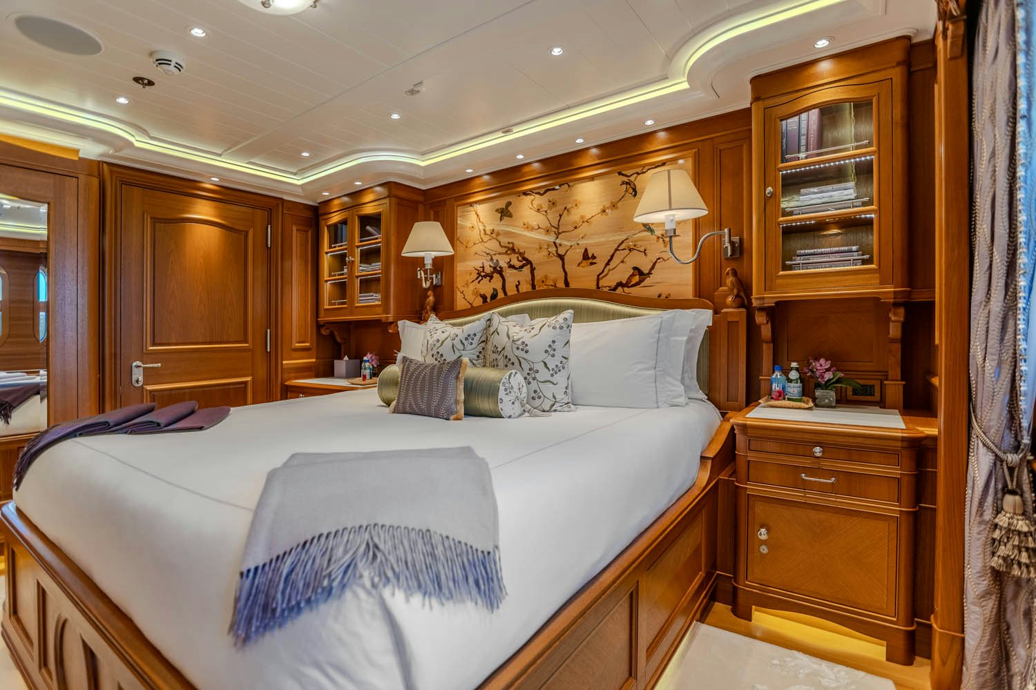 a bedroom with a bed and a dresser aboard SEA OWL Yacht for Charter