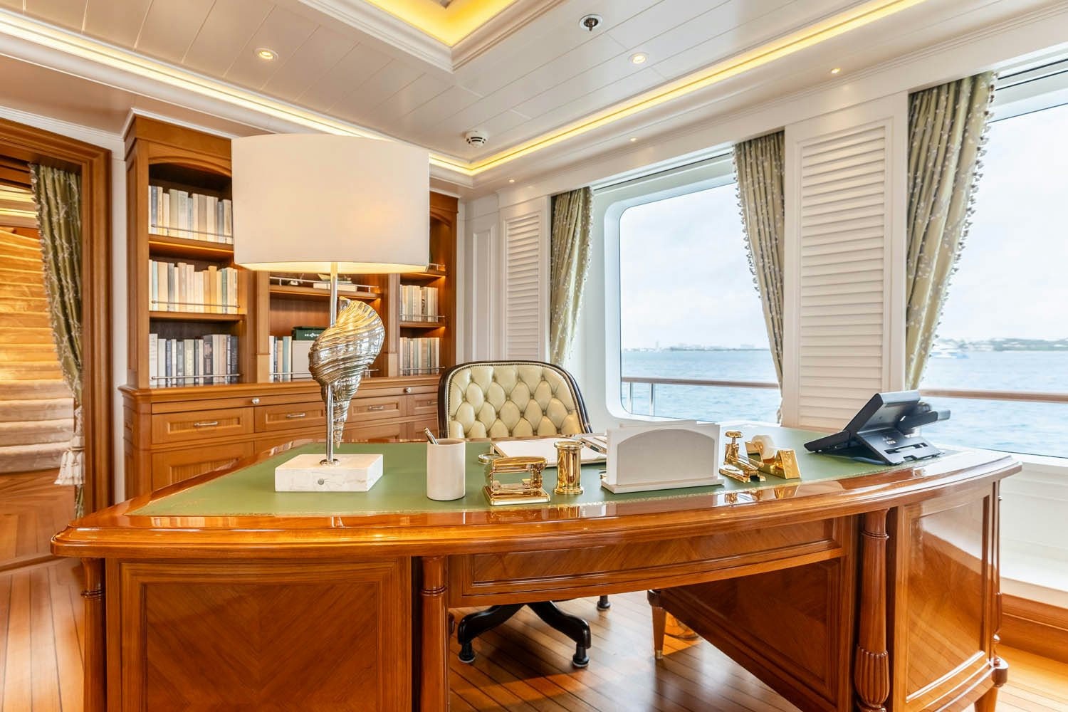 a dining table with a lamp and a window aboard SEA OWL Yacht for Charter