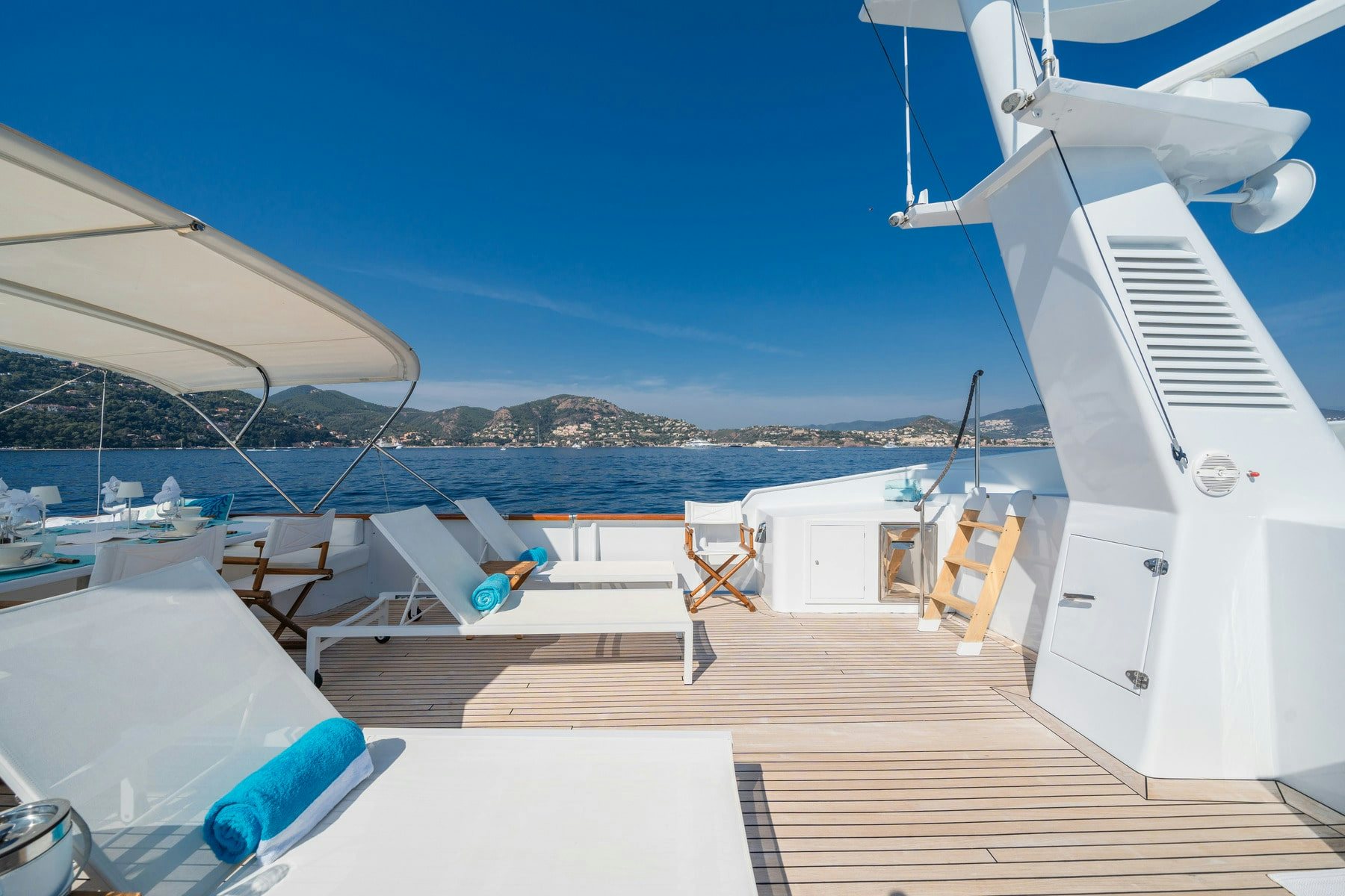 a deck with chairs and a body of water in the background aboard AMMIRAGLIO Yacht for Sale